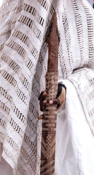 Close-up of a traditional garment and intricately carved wooden staff.