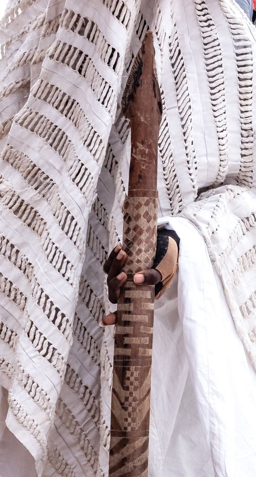 Free Close-up of a traditional garment and intricately carved wooden staff. Stock Photo