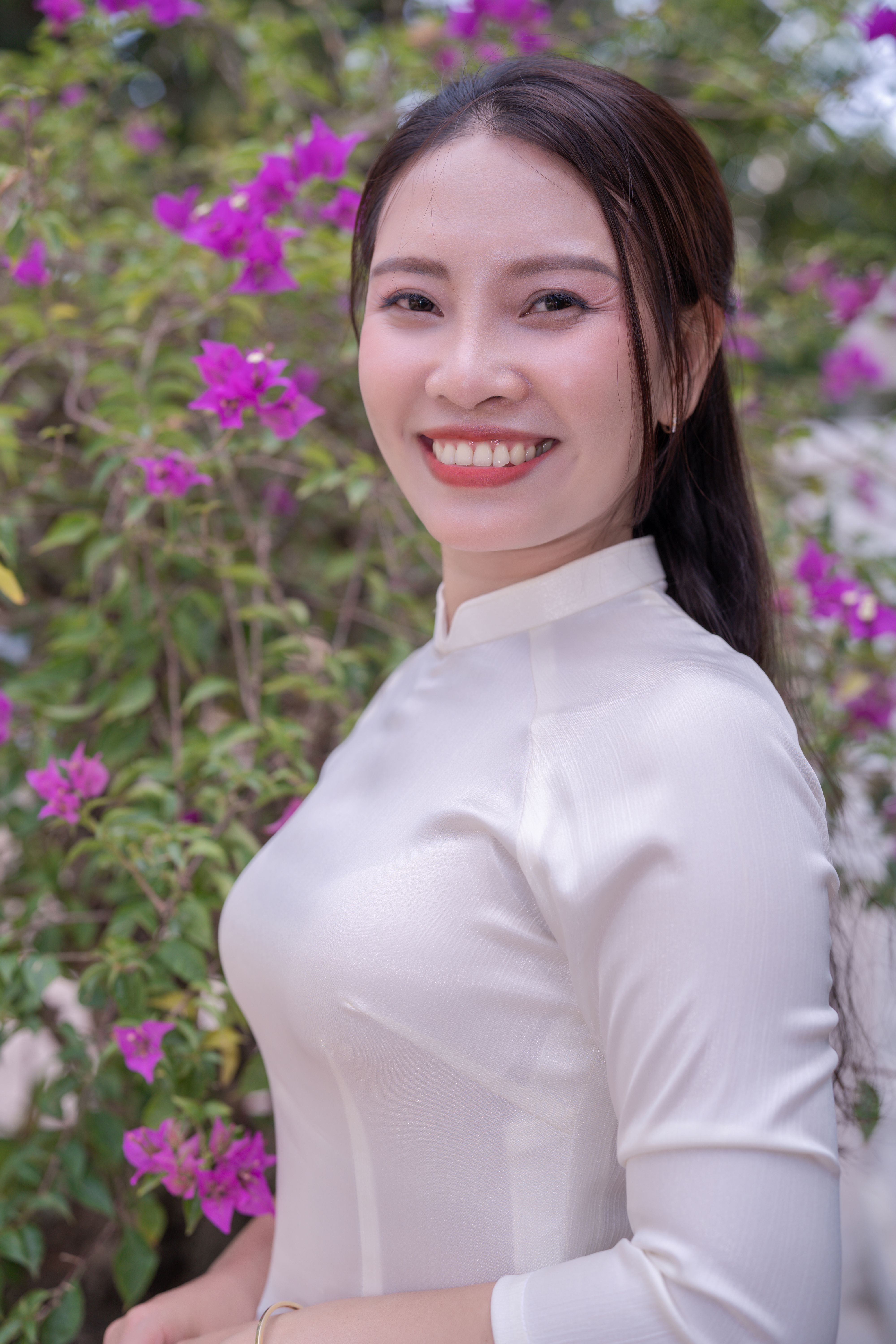 Smiling Woman in Traditional White Dress with Flowers · Free Stock Photo