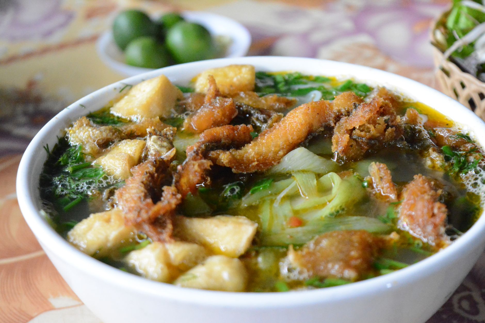Delicious Vietnamese fish noodle soup with crispy fried fish and fresh herbs.