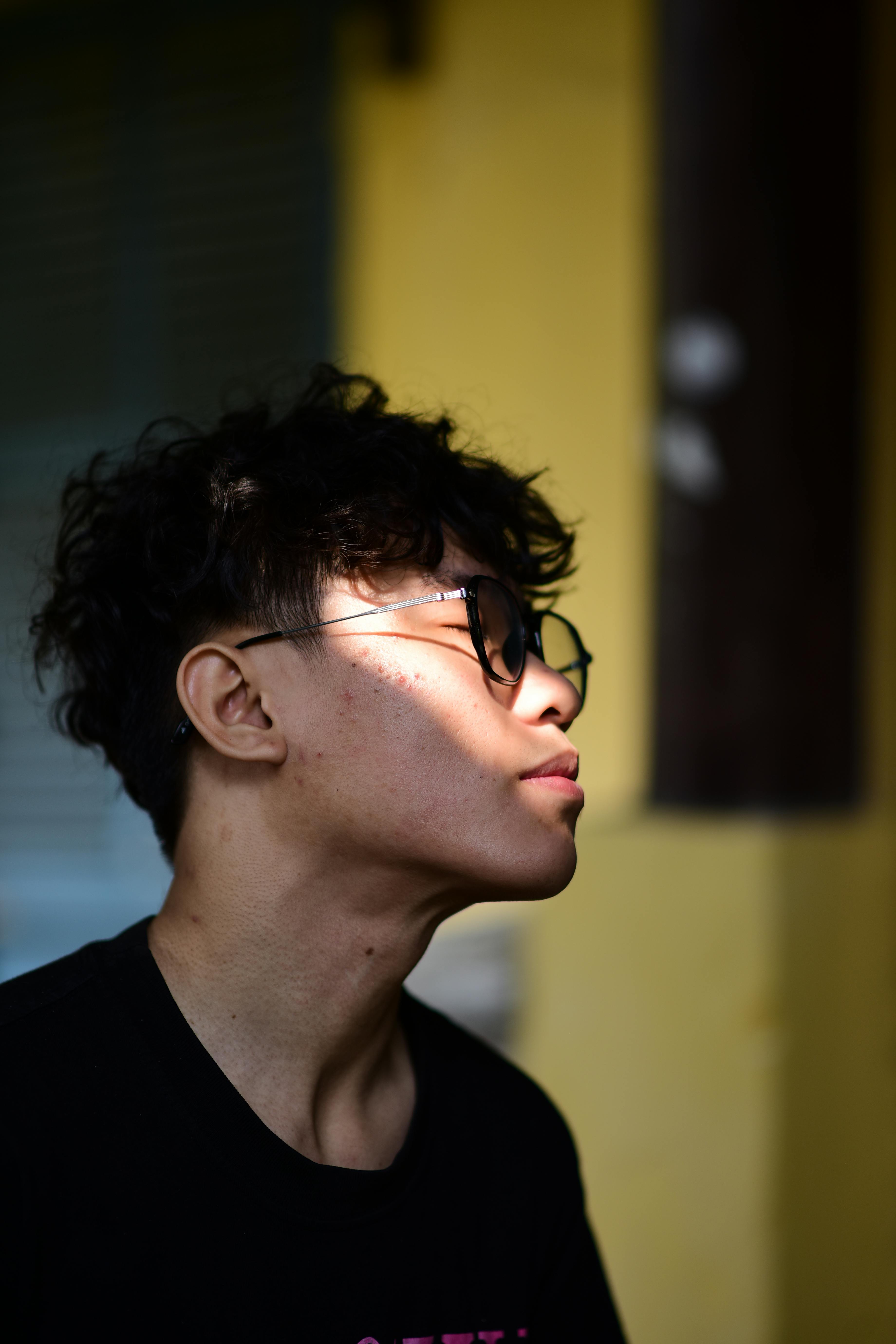 Zadarmo Profilový portrét mladého muža so slnečnými okuliarmi, zachytený v umeleckom osvetlení. Fotka z fotobanky