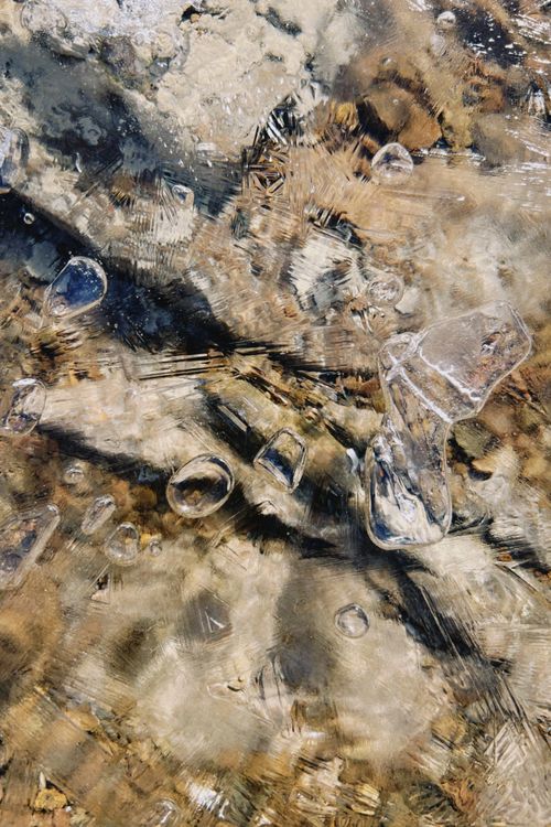 Free Close-up of textured frozen water with visible ice bubbles in a natural outdoor setting. Stock Photo