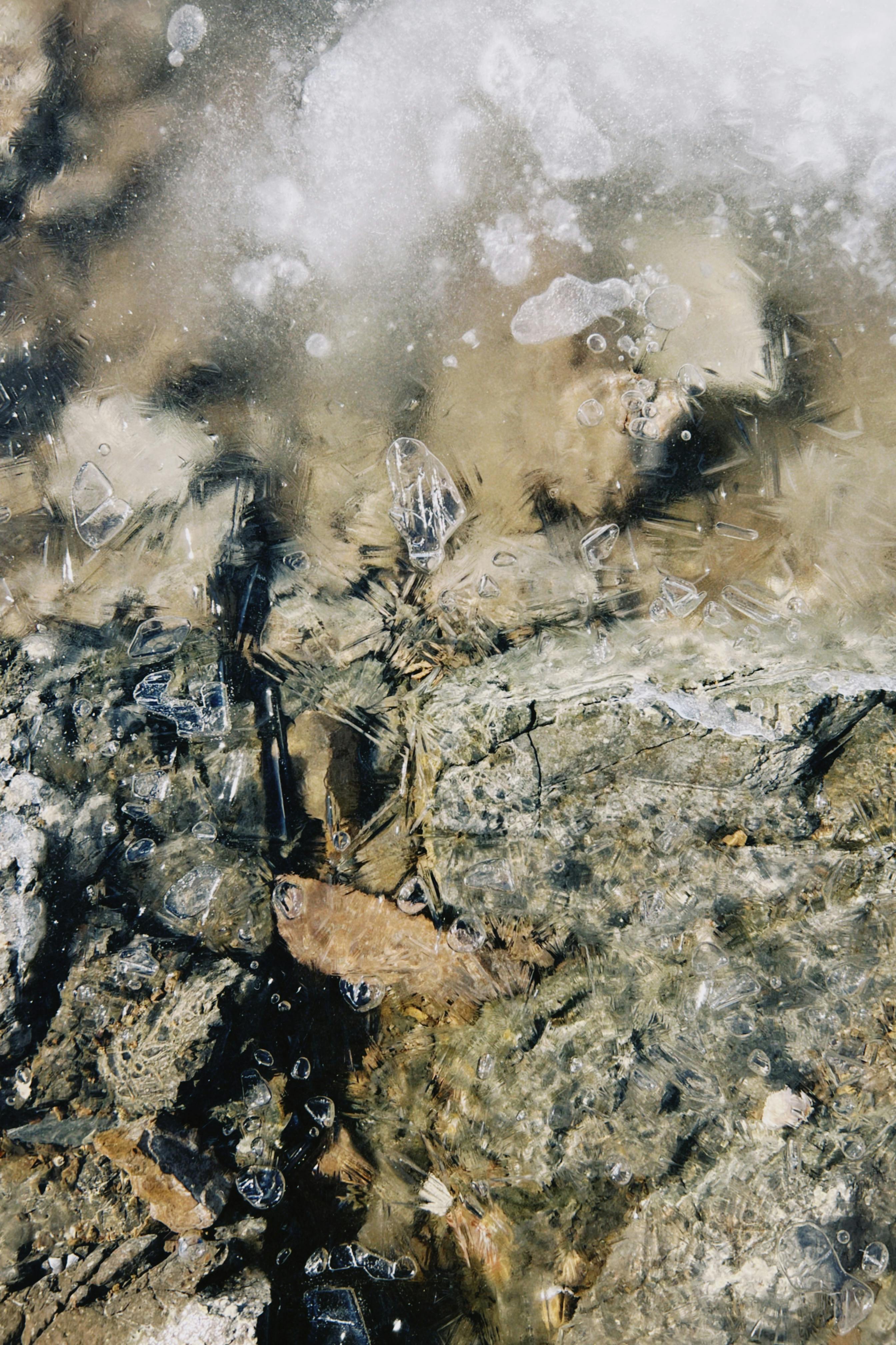 Kostnadsfria Närbild av en frusen bäck med synliga isformationer och stenar under ytan. Stock foto