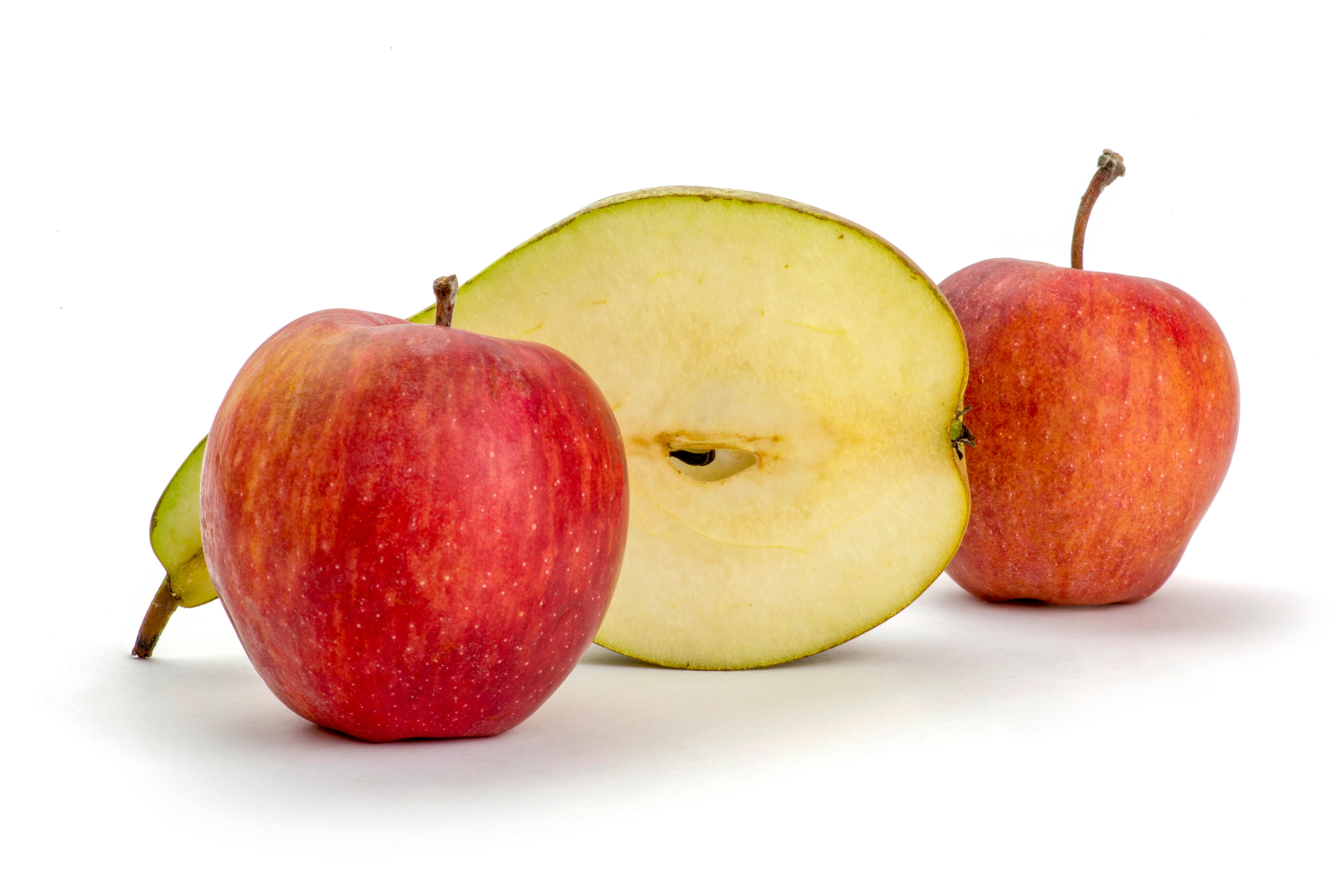 Free Red apples and a sliced apple against a clean white backdrop. Stock Photo