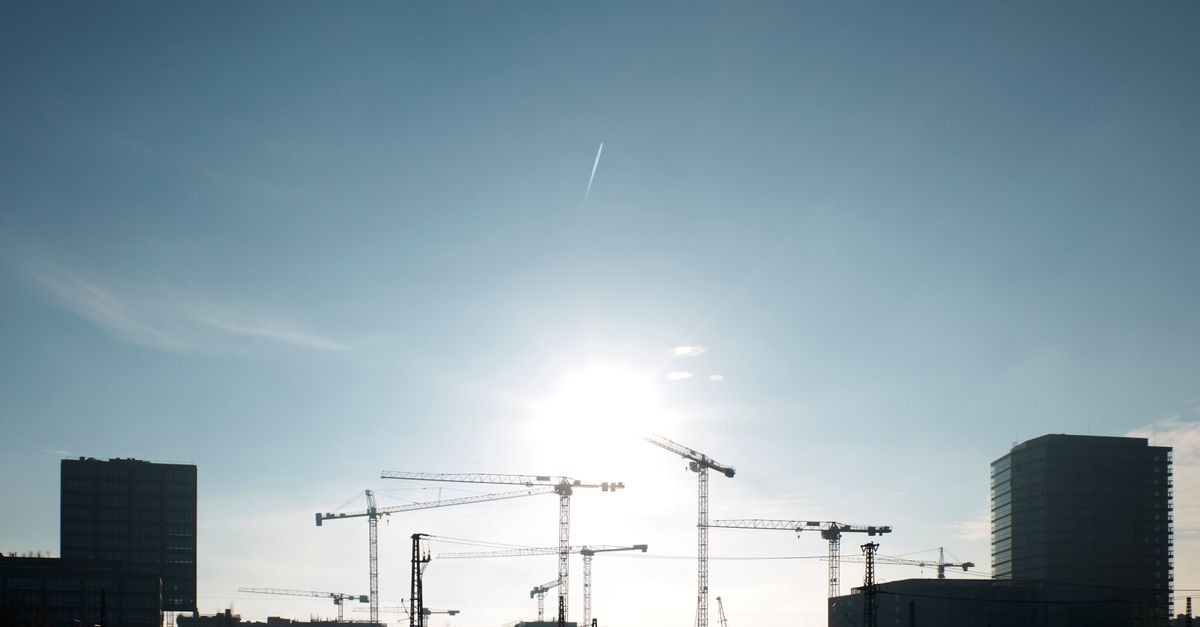 Silhouetten von Baukränen und Gebäuden vor hellem Himmel in Hamburg