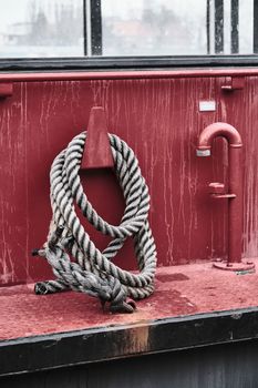 Close-up of a coiled rope on a red metal ship deck in Hamburg's harbor.