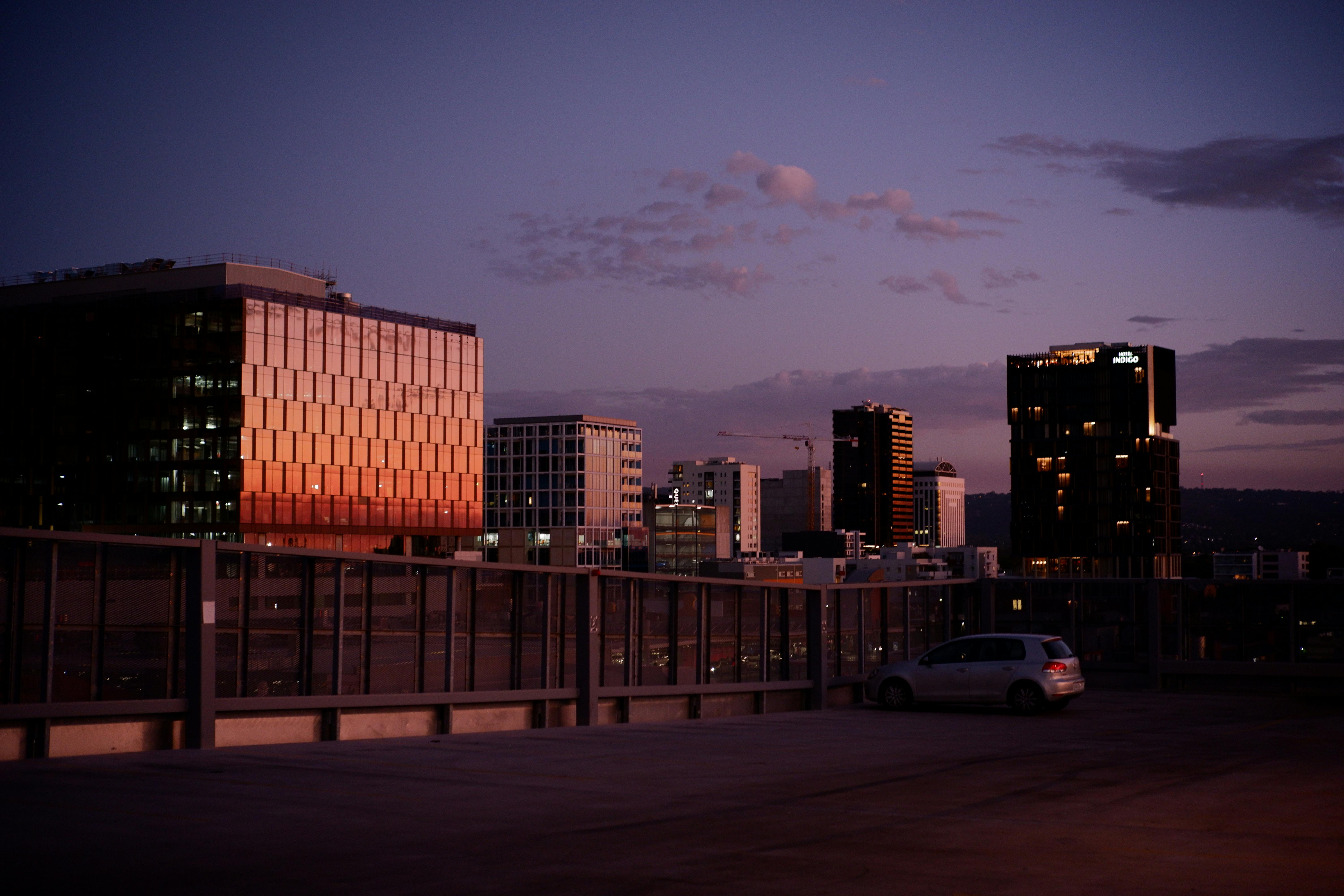 Beautiful twilight view of Adelaide's skyline with modern buildings reflecting sunset hues.