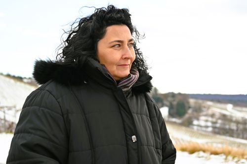 Free A woman in a winter coat stands thoughtfully outdoors in a snowy Weinstadt landscape. Stock Photo