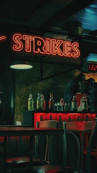 Atmospheric night scene in a bar illuminated by neon lights and a 'Strikes' sign in Egypt.