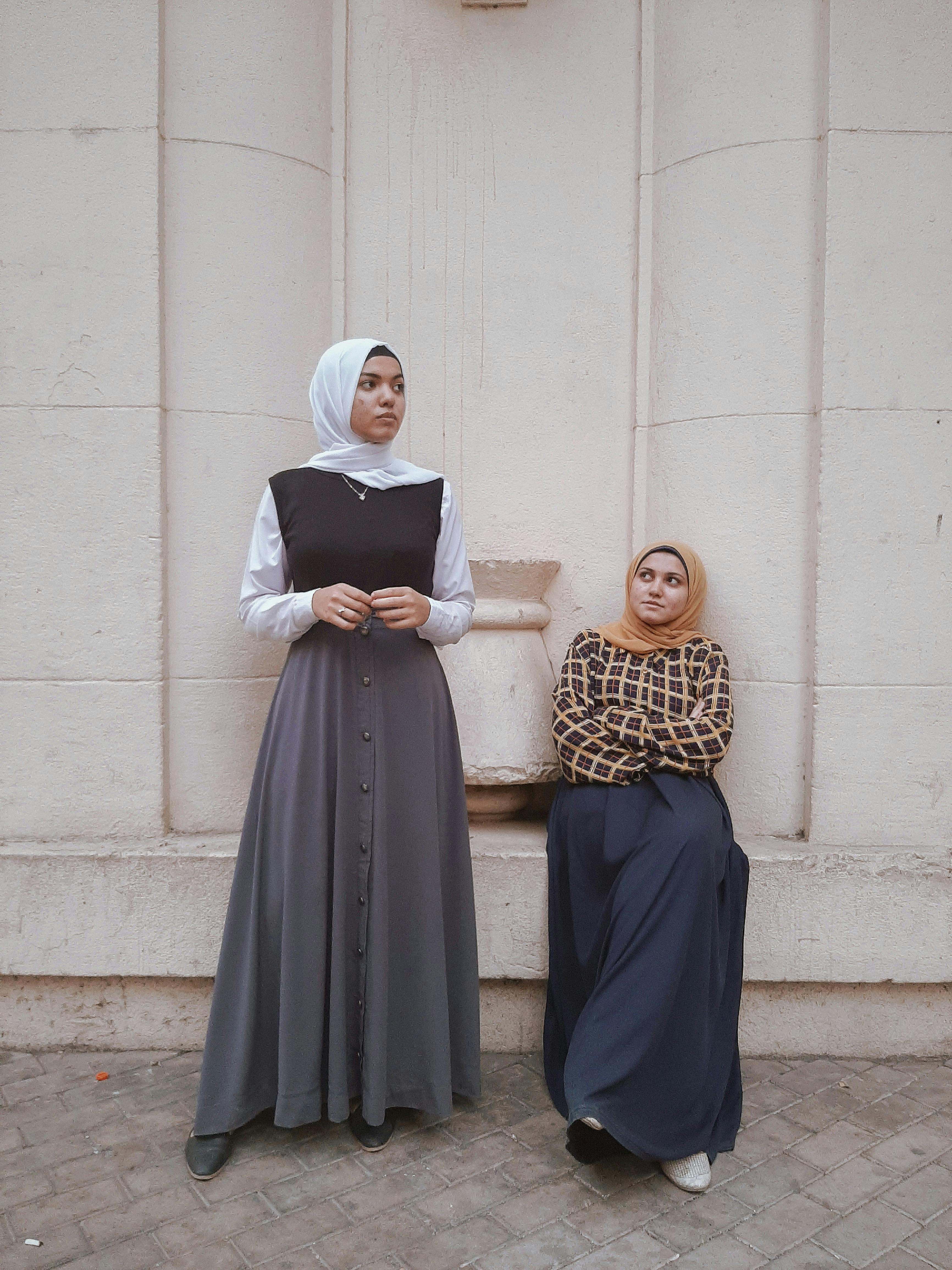 Gratis To kvinner i elegant antrekk poserer mot en egyptisk arkitektonisk bakgrunn. Arkivbilde