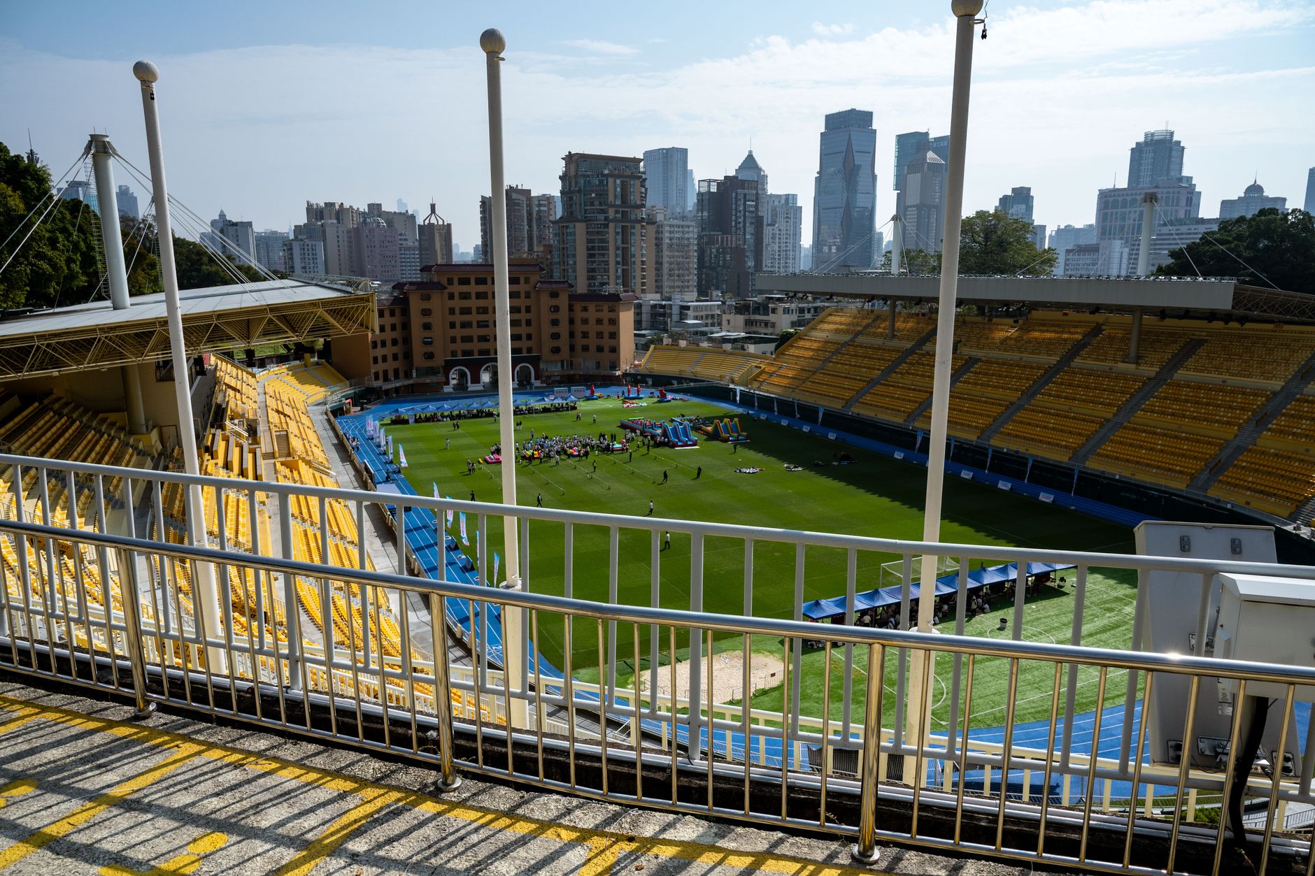 Wide-angle view of a Guangzhou sports stadium with city skyscrapers in the background.