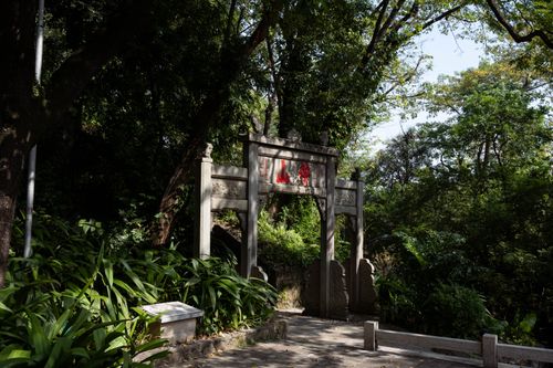 Free An ancient stone gate surrounded by lush greenery in a peaceful forest setting in Guangzhou, China. Stock Photo