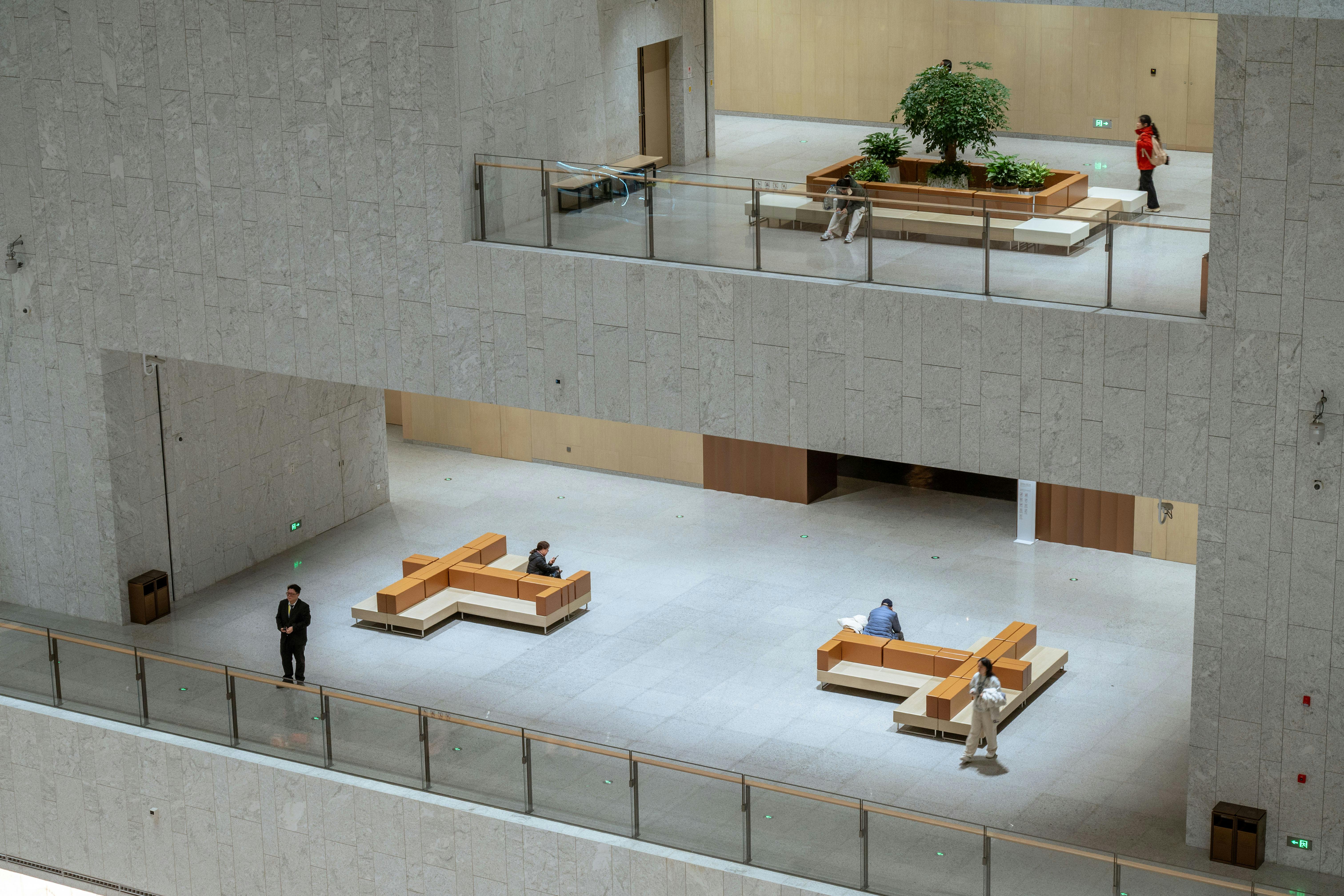 Spacious modern atrium in a Shanghai building featuring minimalistic design with people sitting and walking