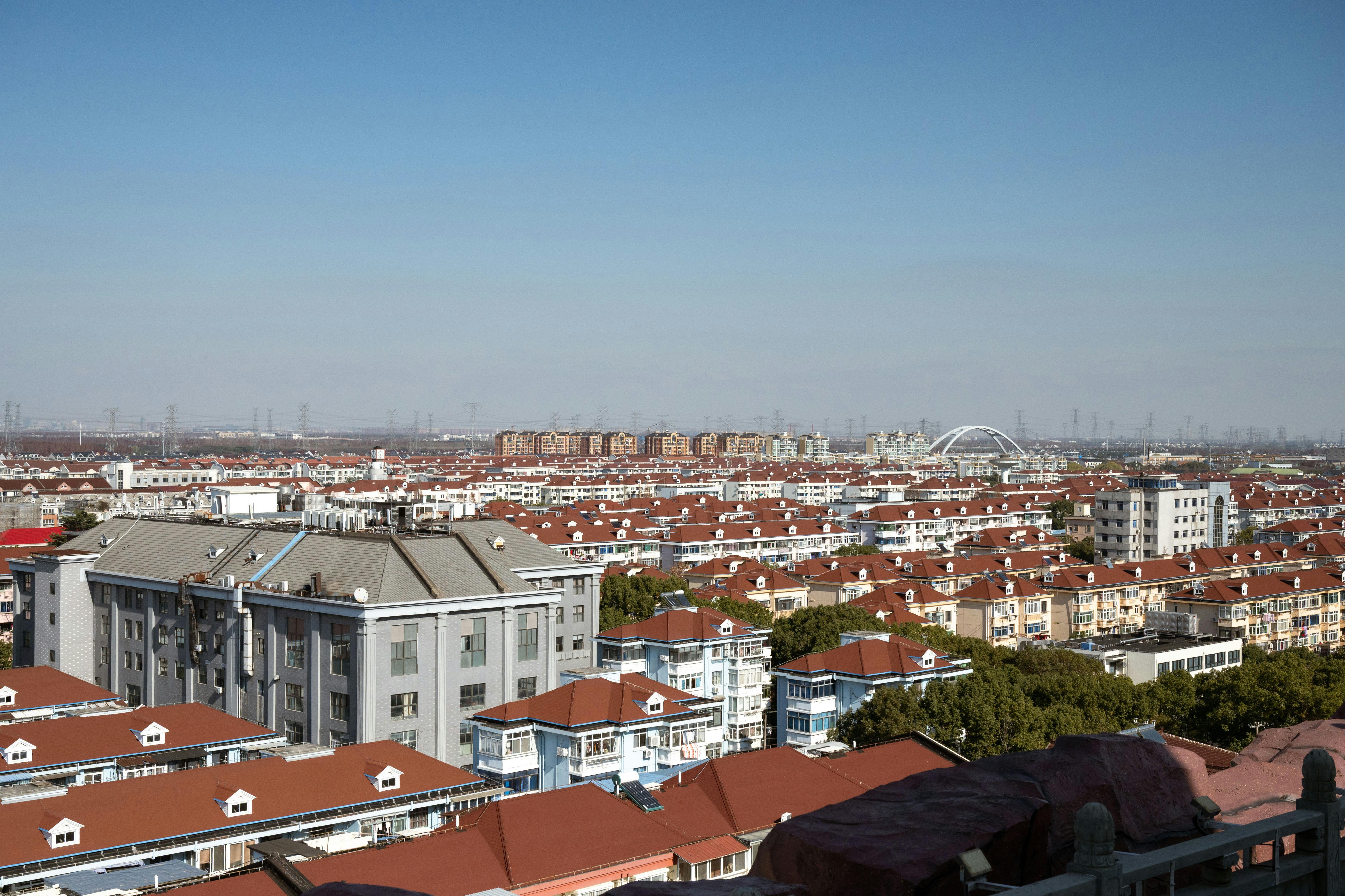 A scenic aerial view of Shanghai's red-roofed residential district under a clear blue sky