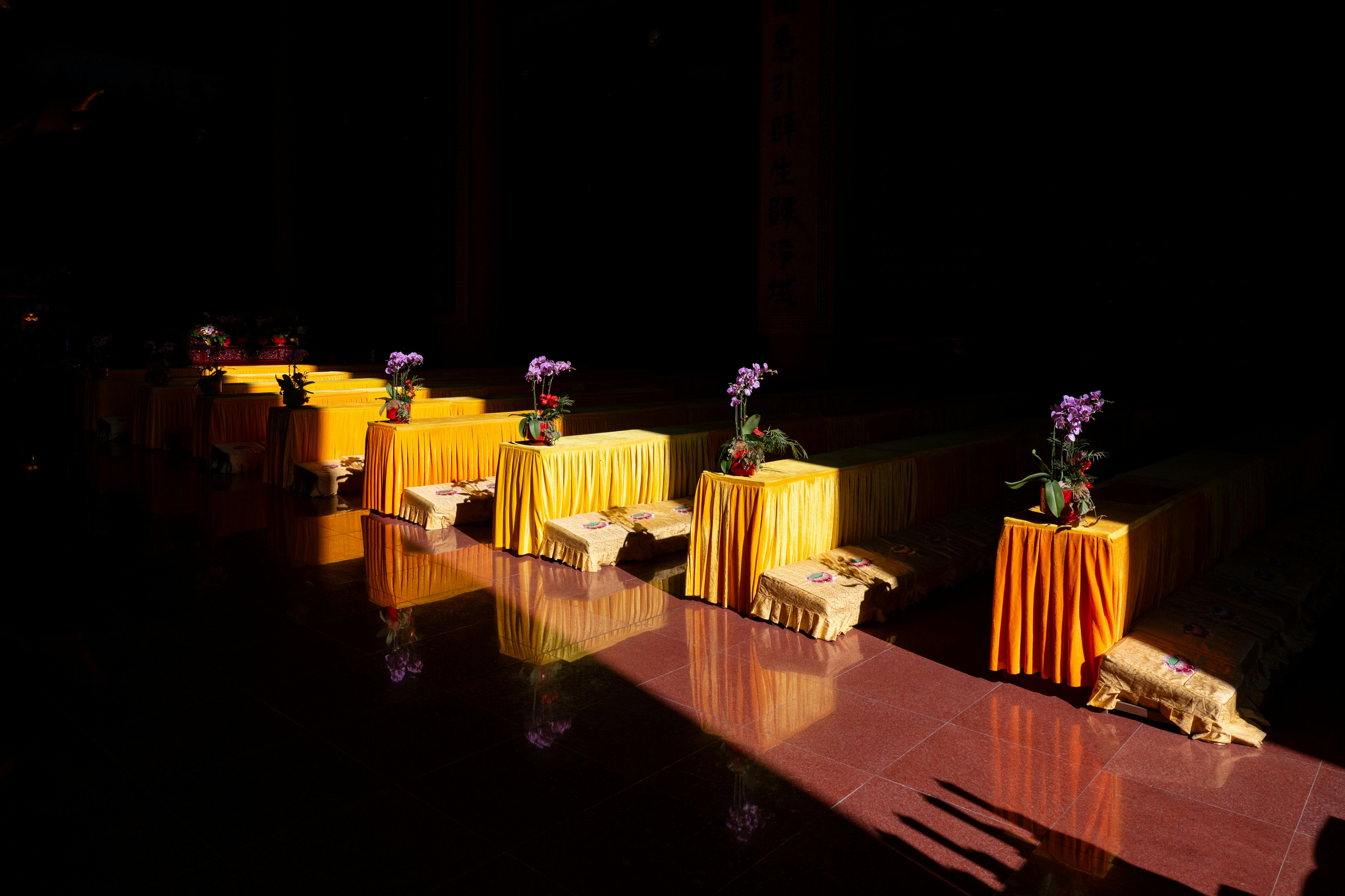 ingyenes Sárga terítőkkel és virágokkal díszített oltársor napfényben egy sanghaji templomban, Kínában. Stockfotó