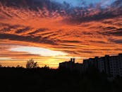 城市天际线的轮廓映衬着充满活力的色彩和戏剧性的日落云层