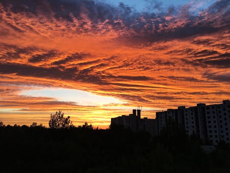 城市天际线的轮廓映衬着充满活力的色彩和戏剧性的日落云层