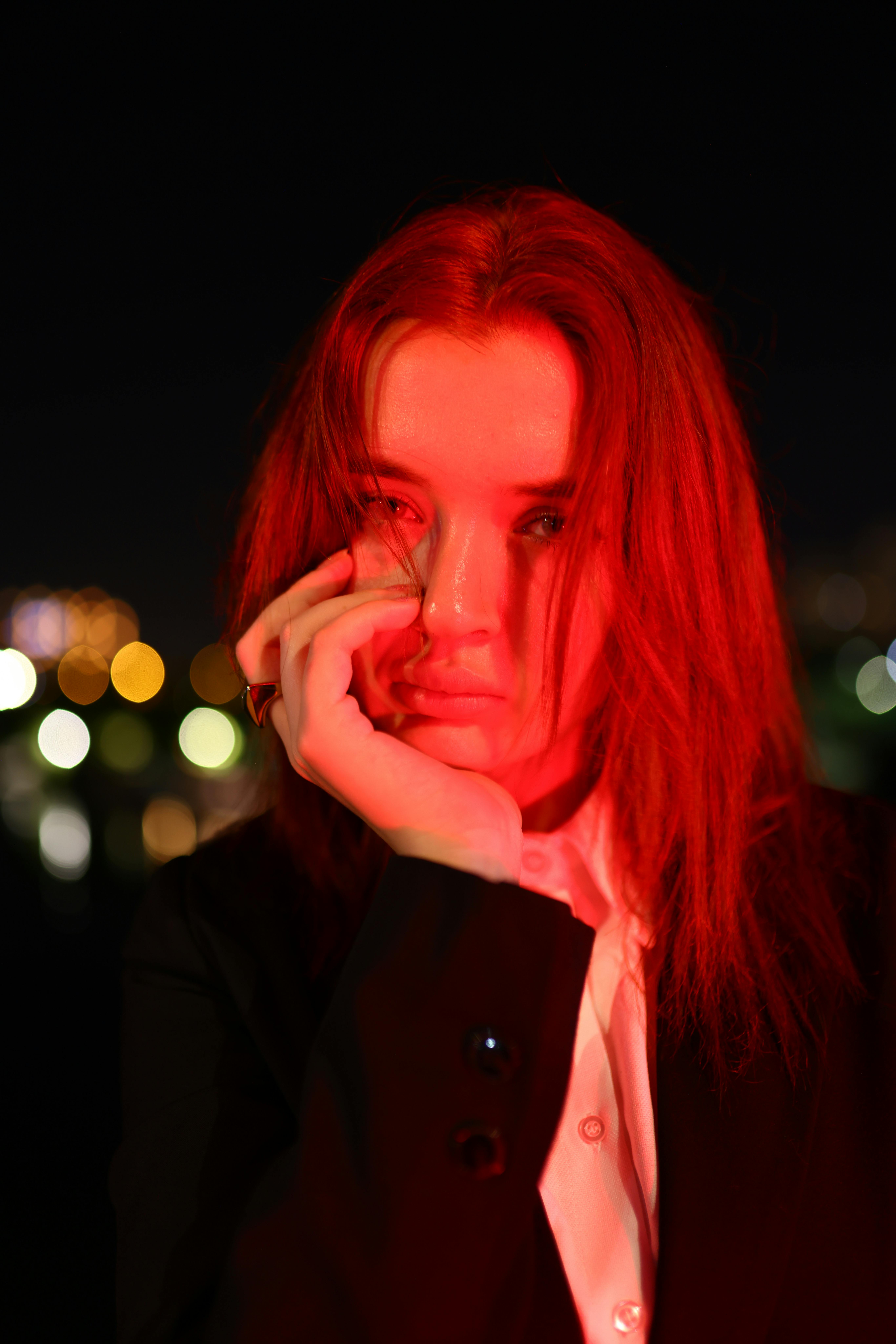 ingyenes Érzelmes éjszakai portré intenzív vörös fénnyel és városi bokeh-val. Stockfotó