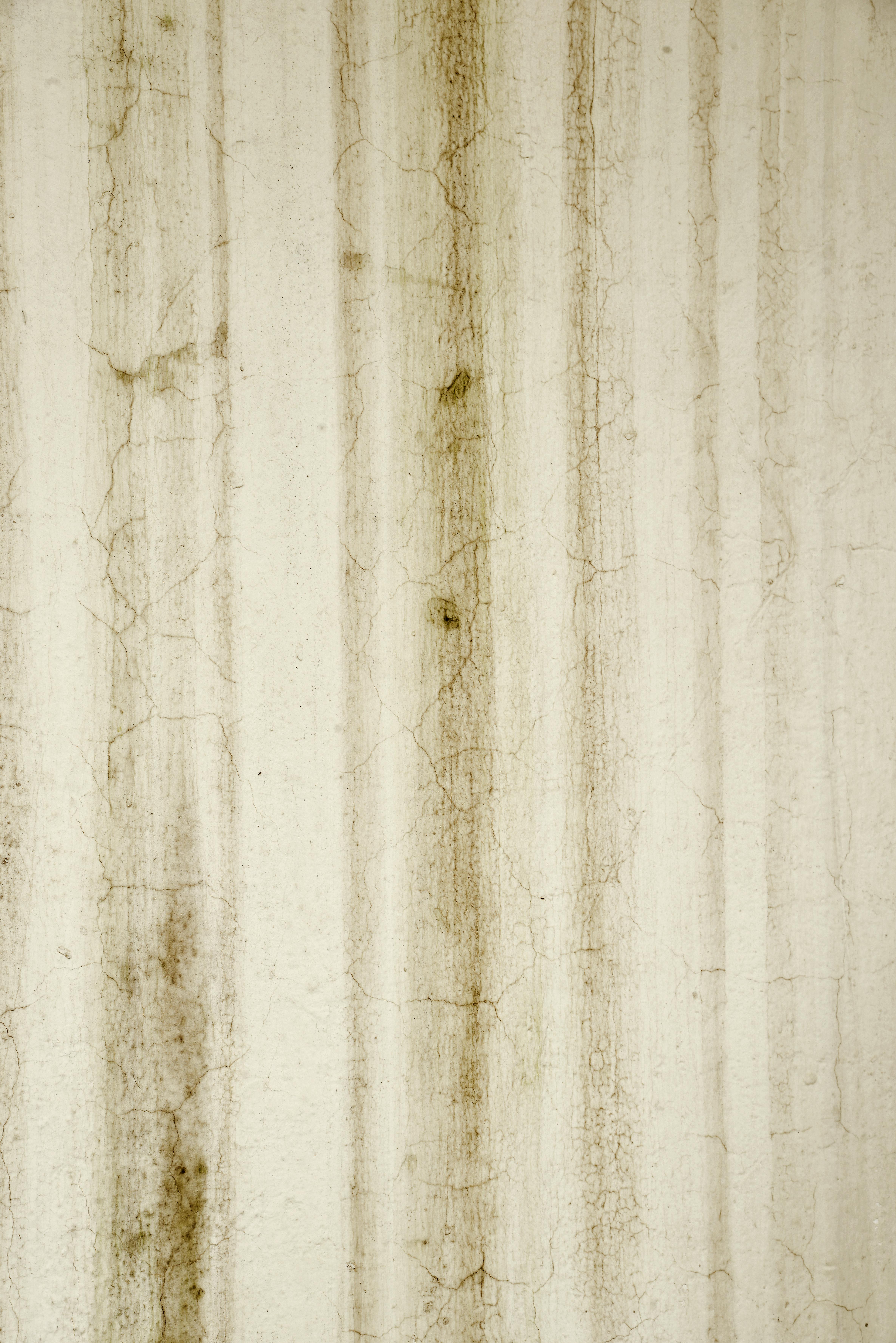 gratis Close-up van een oude, gestructureerde muur met verticale lijnen en scheuren, die een abstract patroon vormen. Stockfoto