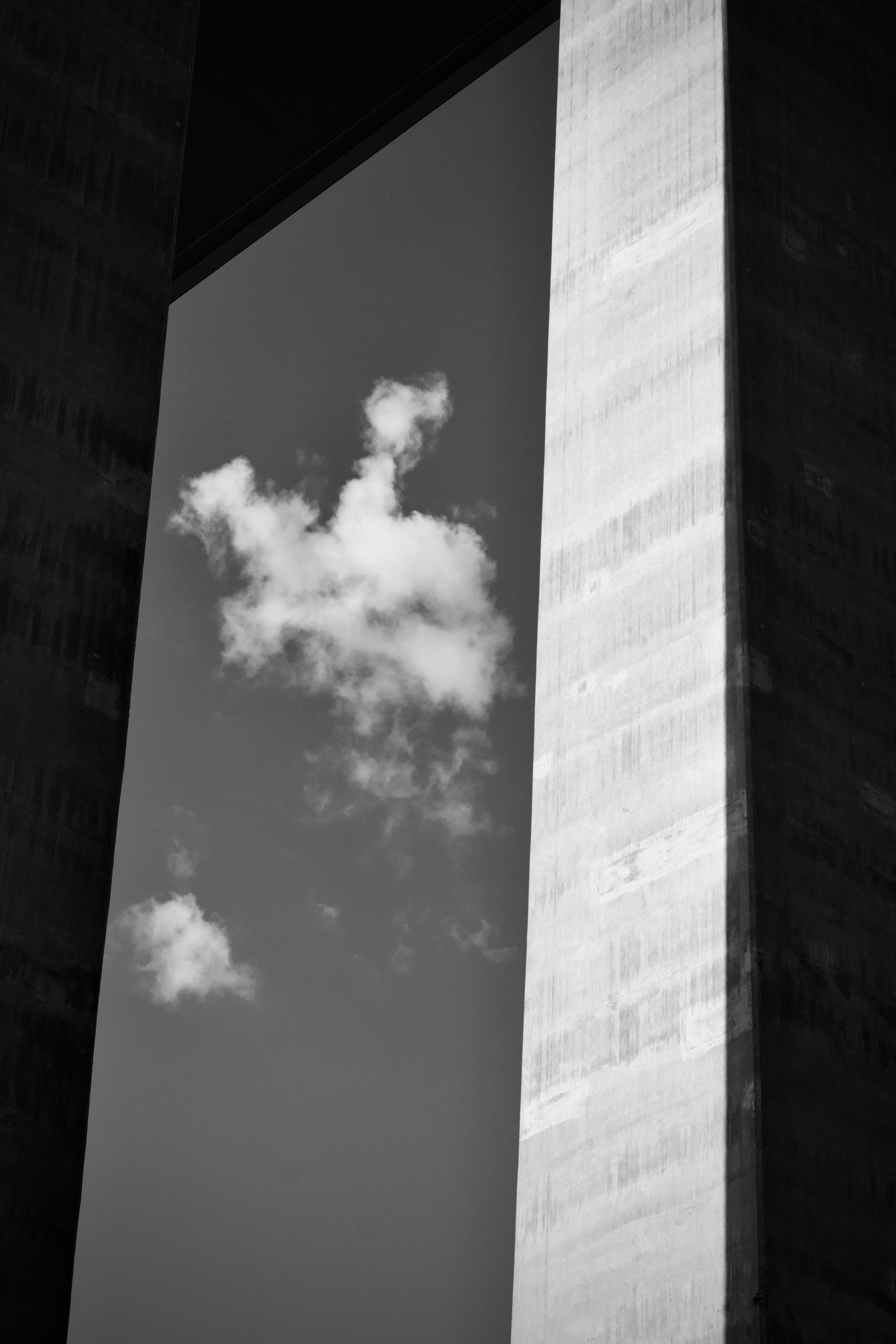 De franc Imatge en blanc i negre d'una estructura d'edifici amb núvols flotants Foto d'estoc