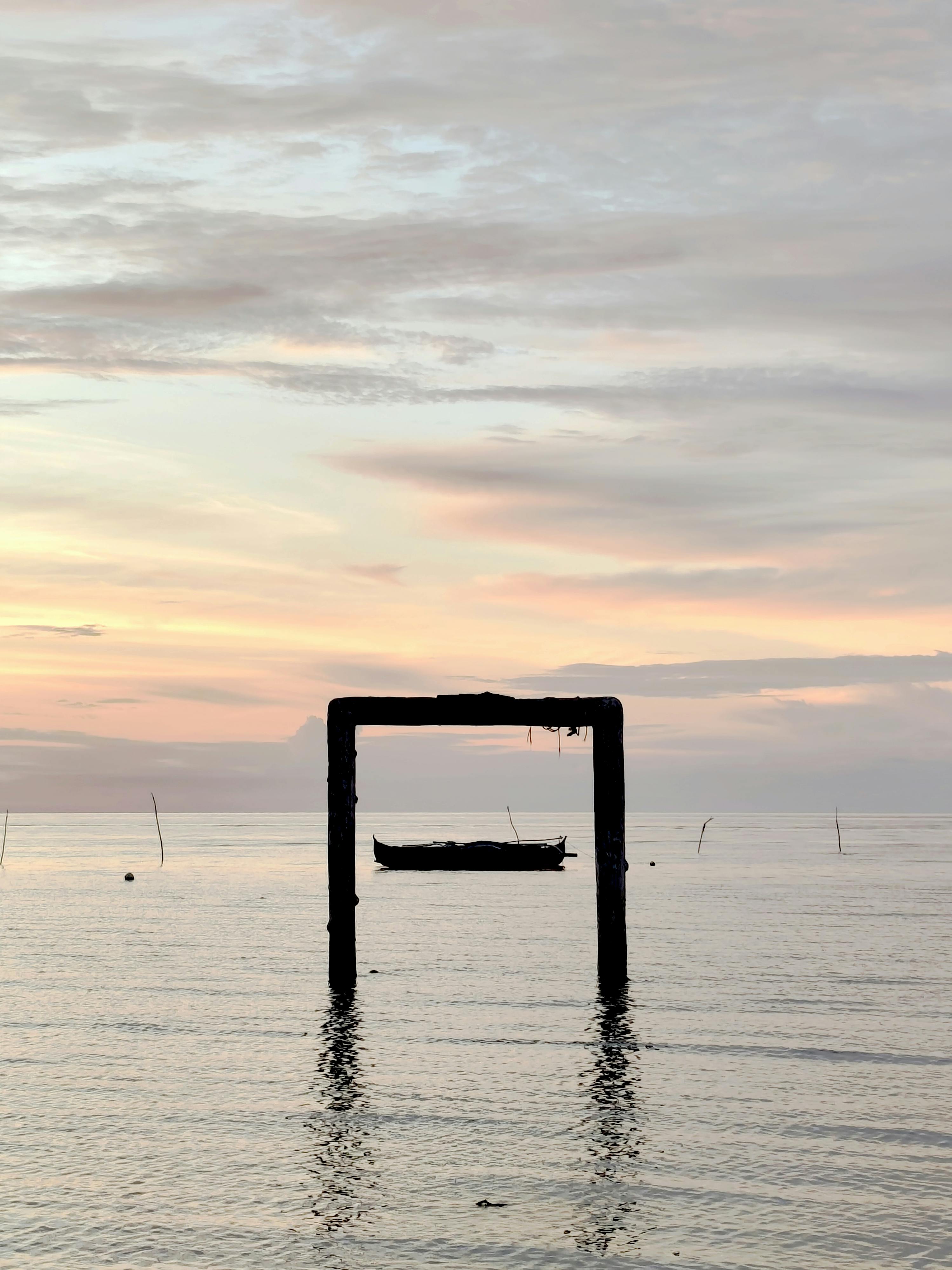 Miễn phí Một khung cảnh biển thanh bình lúc bình minh với hình ảnh chiếc thuyền in bóng và mặt nước tĩnh lặng được ghi lại ở Philippines. Ảnh lưu trữ