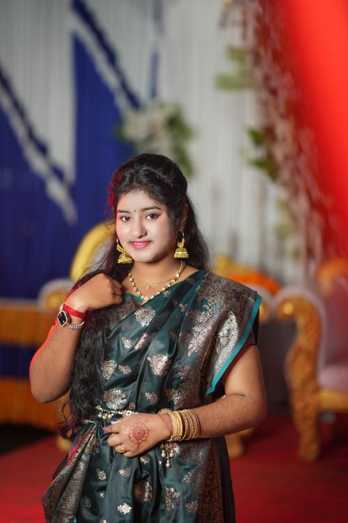 Free Portrait of a woman in traditional attire, smiling at an indoor event setting. Stock Photo