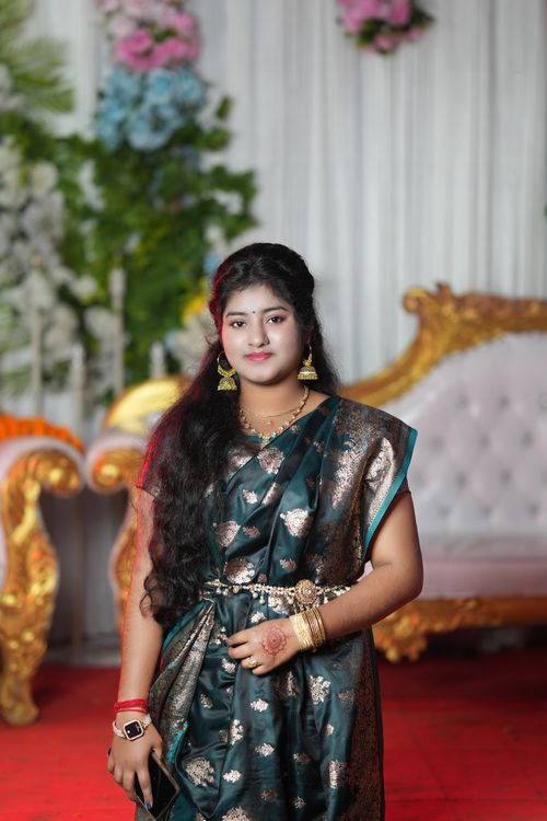 Free A woman in traditional attire poses gracefully at a festive indoor occasion, showcasing cultural elegance. Stock Photo