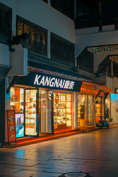 Illuminated retail store in Asian shopping district at night.