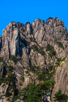 A stunning view of the rugged peaks of Huangshan Mountain in China, showcasing its steep cliffs and towering heights.