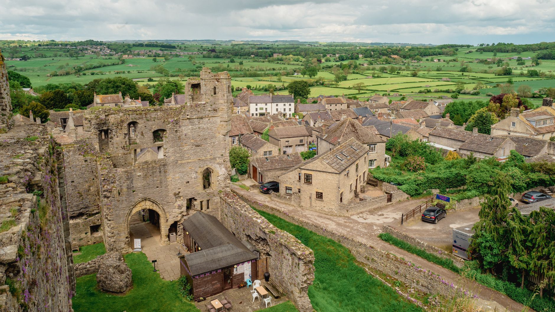 A scenic view of Middleham Castle ruins and surrounding countryside in Middleham, England.
