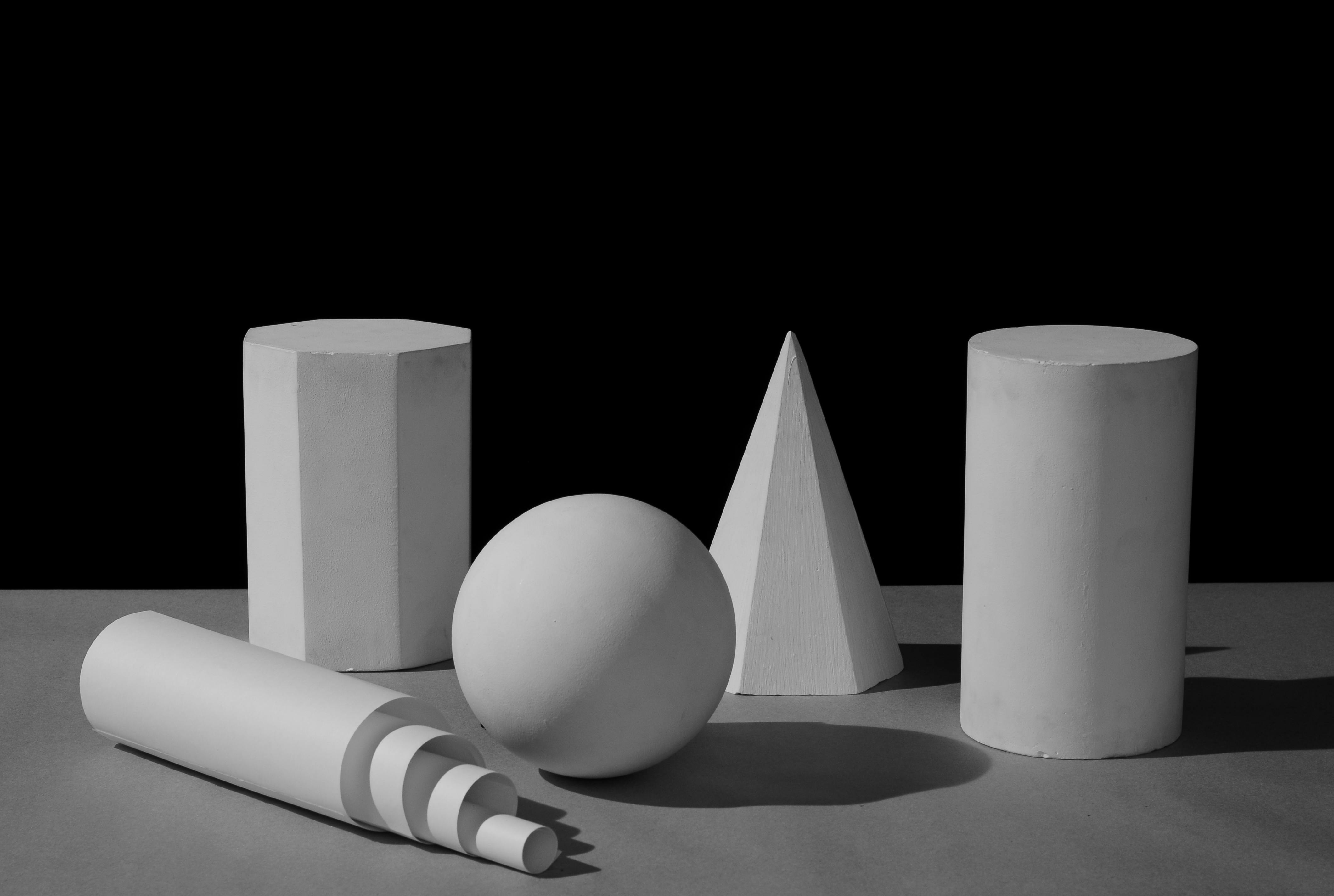 Ücretsiz Çarpıcı ışıklandırma altında çeşitli geometrik şekilleri sergileyen siyah beyaz fotoğraf. Stok Fotoğraflar