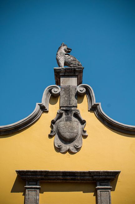 Photograph of a coyote sculpture atop a historic building in Coyoacán, Mexico City.