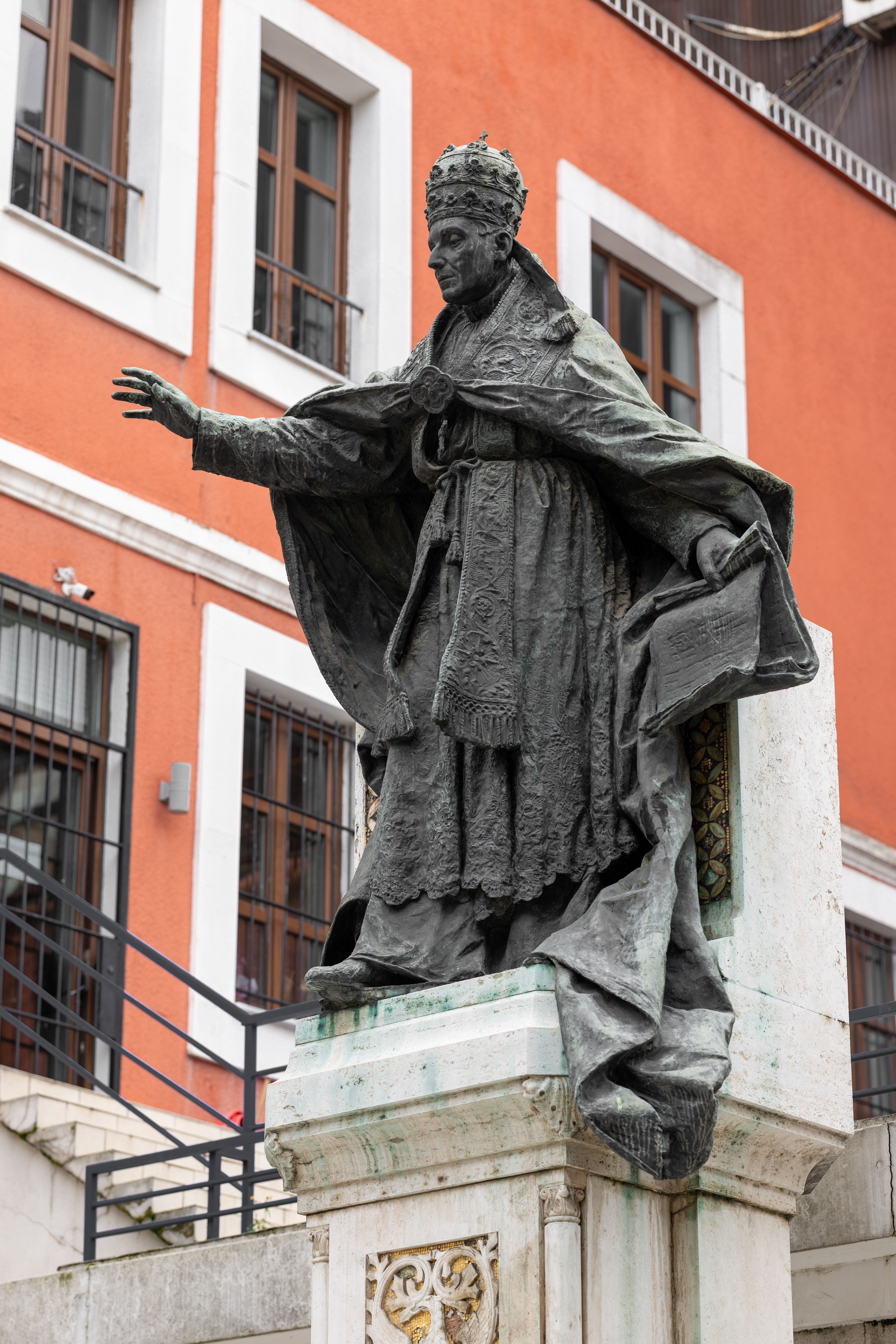 Bronze statue in front of red building in İstanbul, Türkiye.