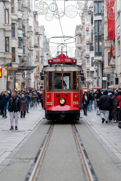 Free Iconic red tram on busy İstiklal Avenue, Istanbul, showcasing urban life and architecture. Stock Photo