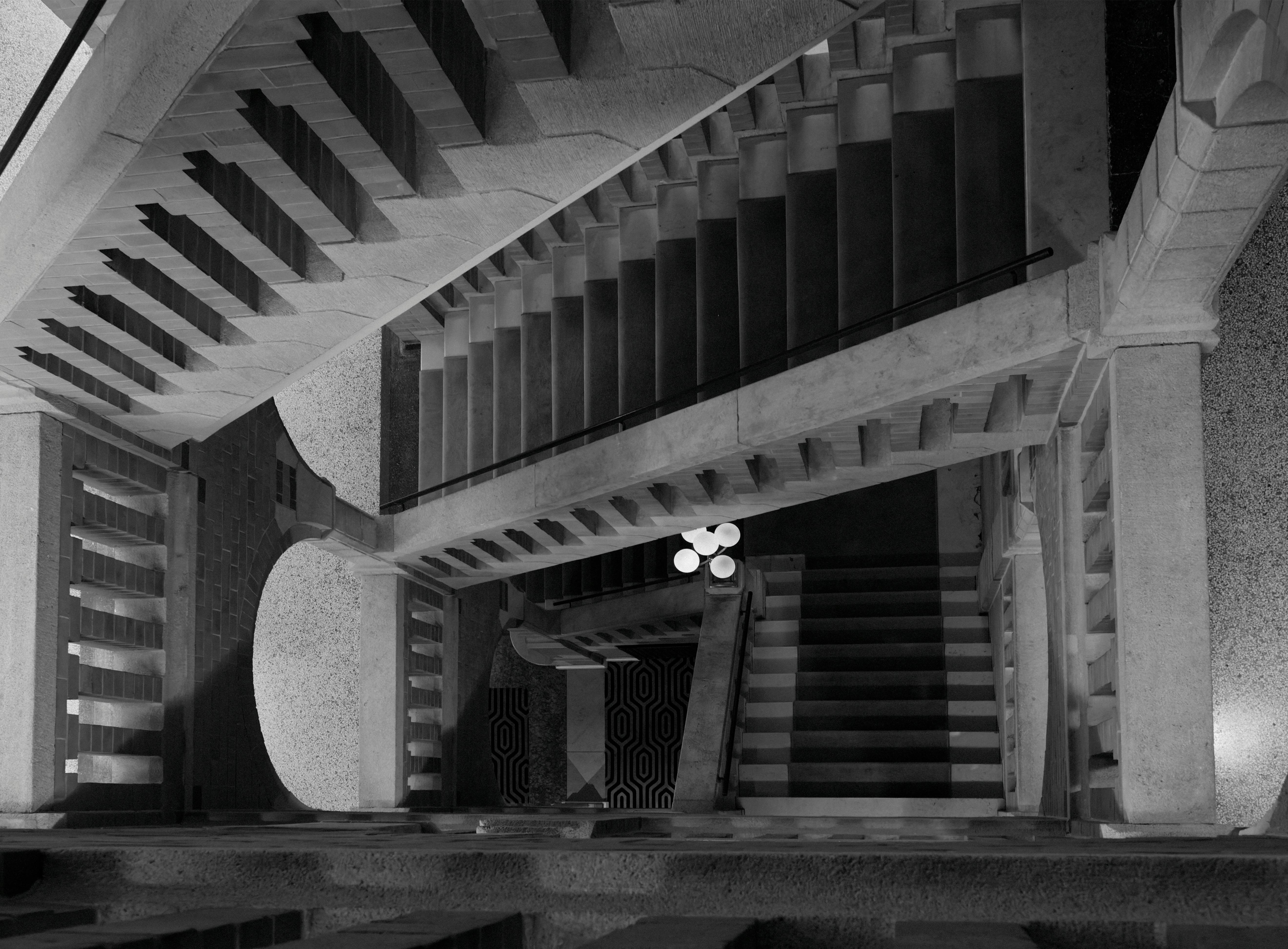 Eindrucksvolles Schwarz-Weiß-Foto einer architektonischen Treppe aus der Vogelperspektive.