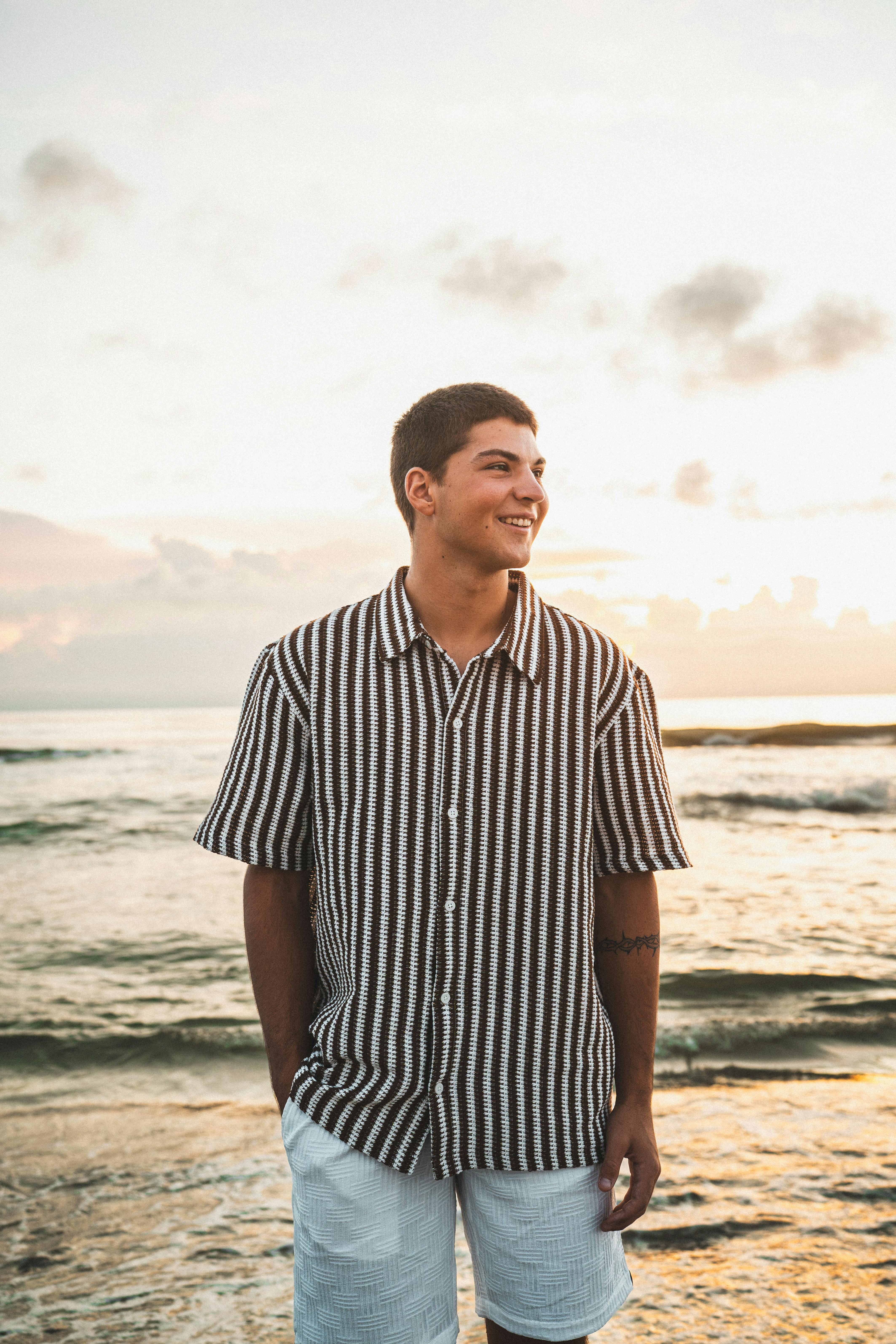 Kostnadsfria En ung man ler nära havet på Melbourne Beach, Florida under soluppgången. Stock foto