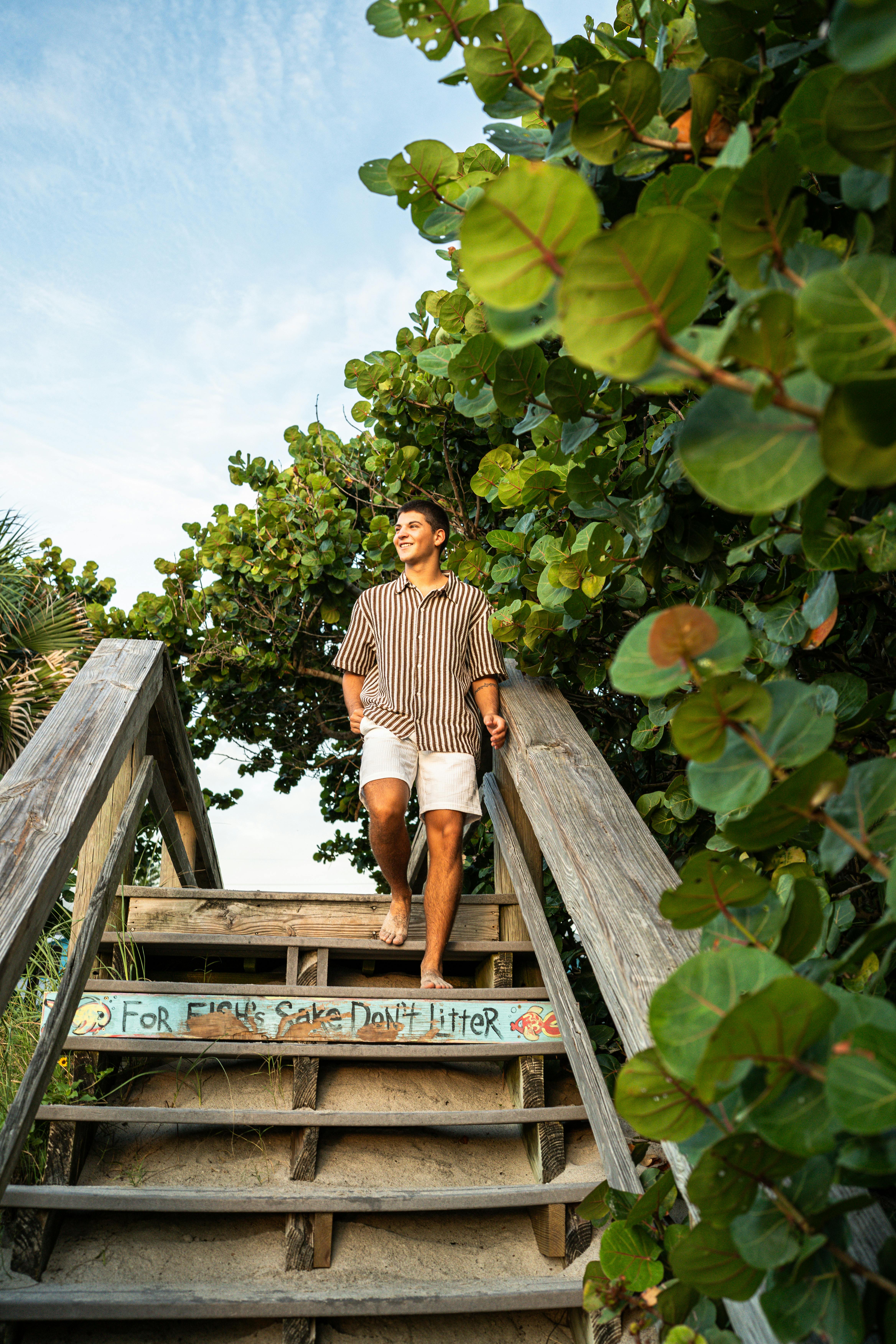 Gratis Ung mann går ned tretrapper på stranden omgitt av frodig grøntområde i Melbourne Beach, Florida. Arkivbilde