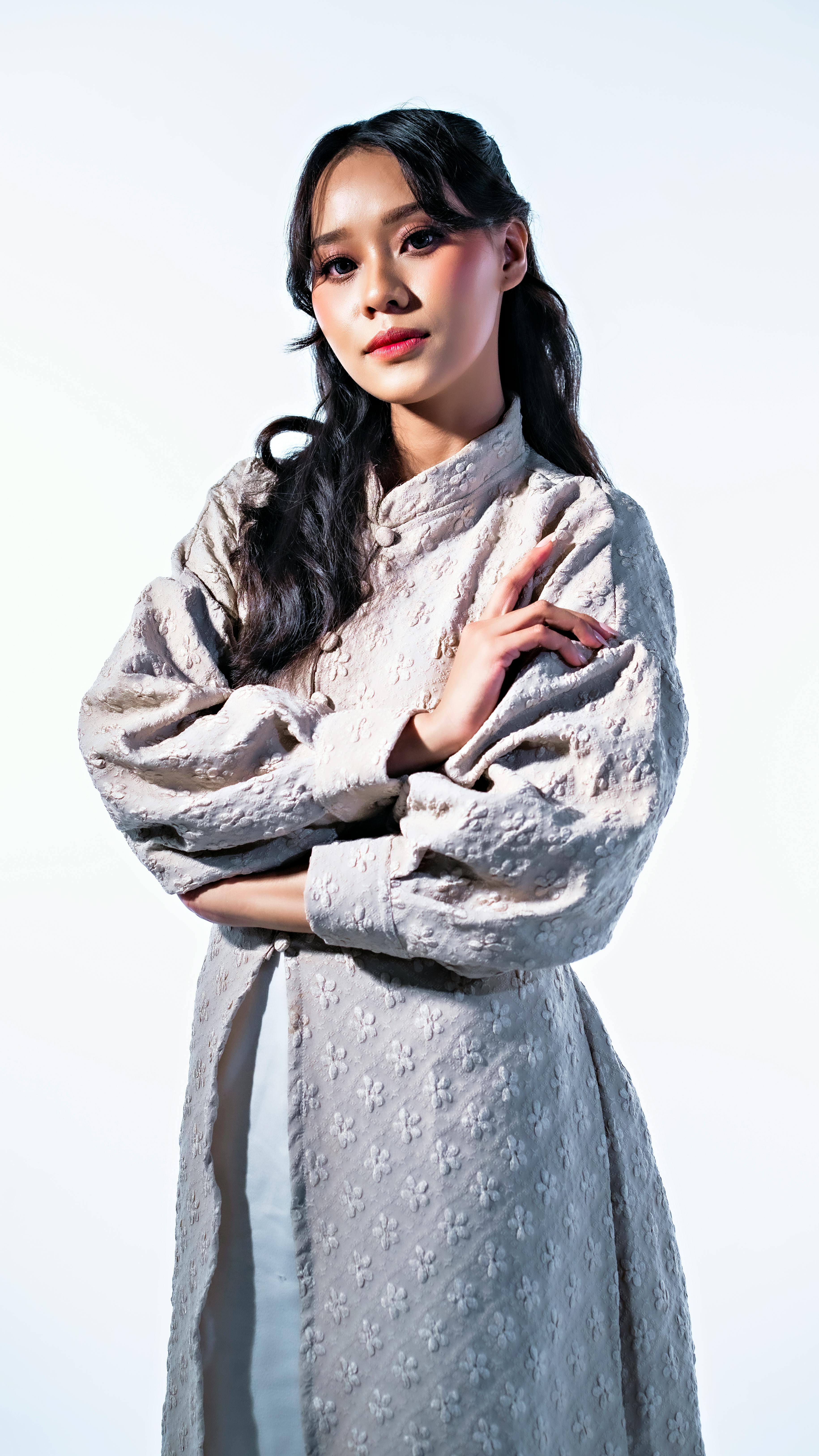 Portrait of a woman in a textured, vintage-style dress with a serene pose.