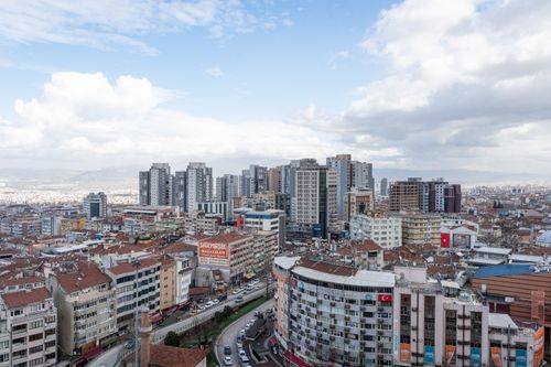 Free A bustling cityscape of Izmir showcasing modern high-rise buildings under a partly cloudy sky. Stock Photo
