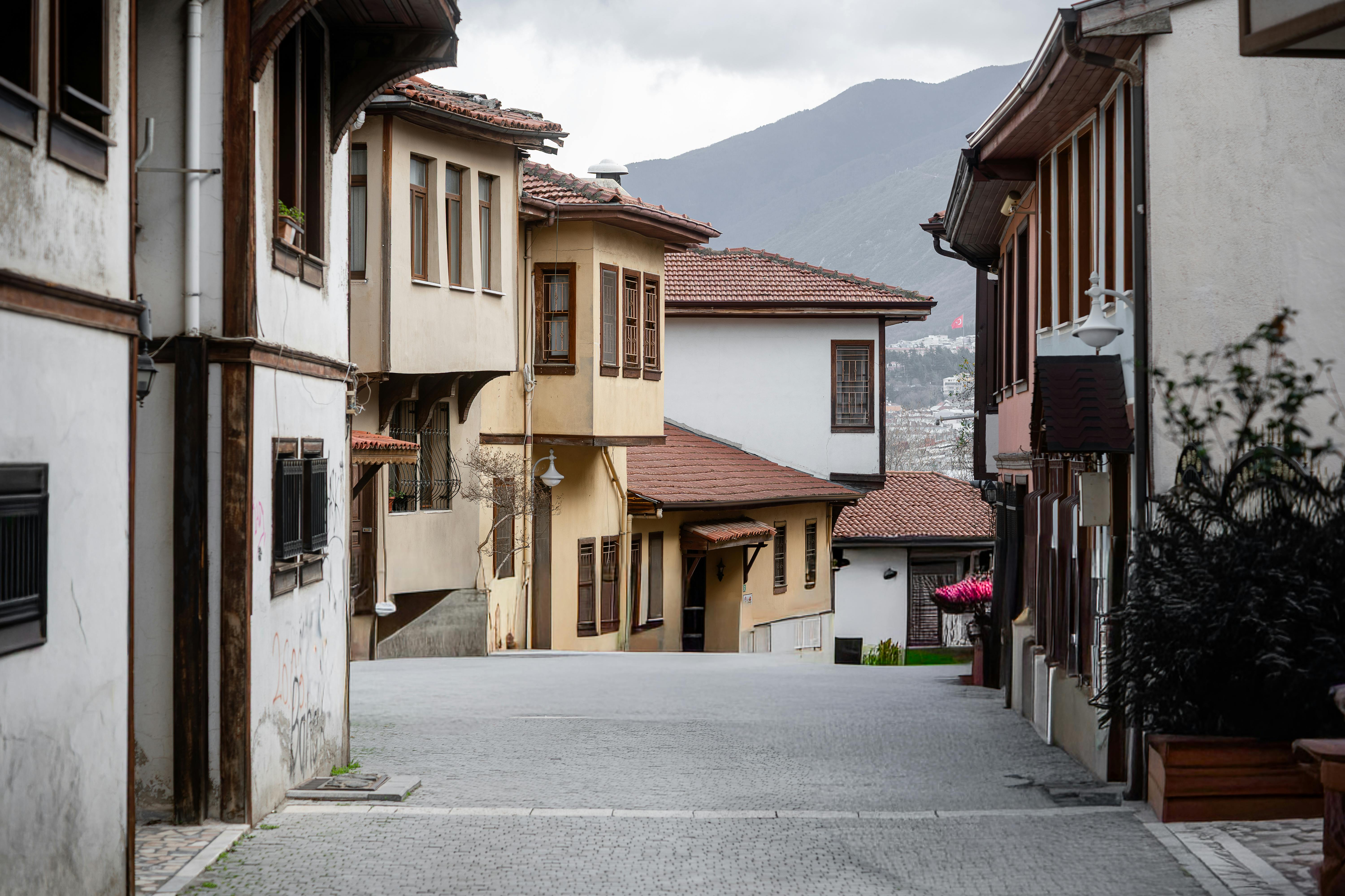 Gratis Sjarmerende historisk gate omkranset av tradisjonelle hus og brostein, som skaper en nostalgisk atmosfære. Arkivbilde
