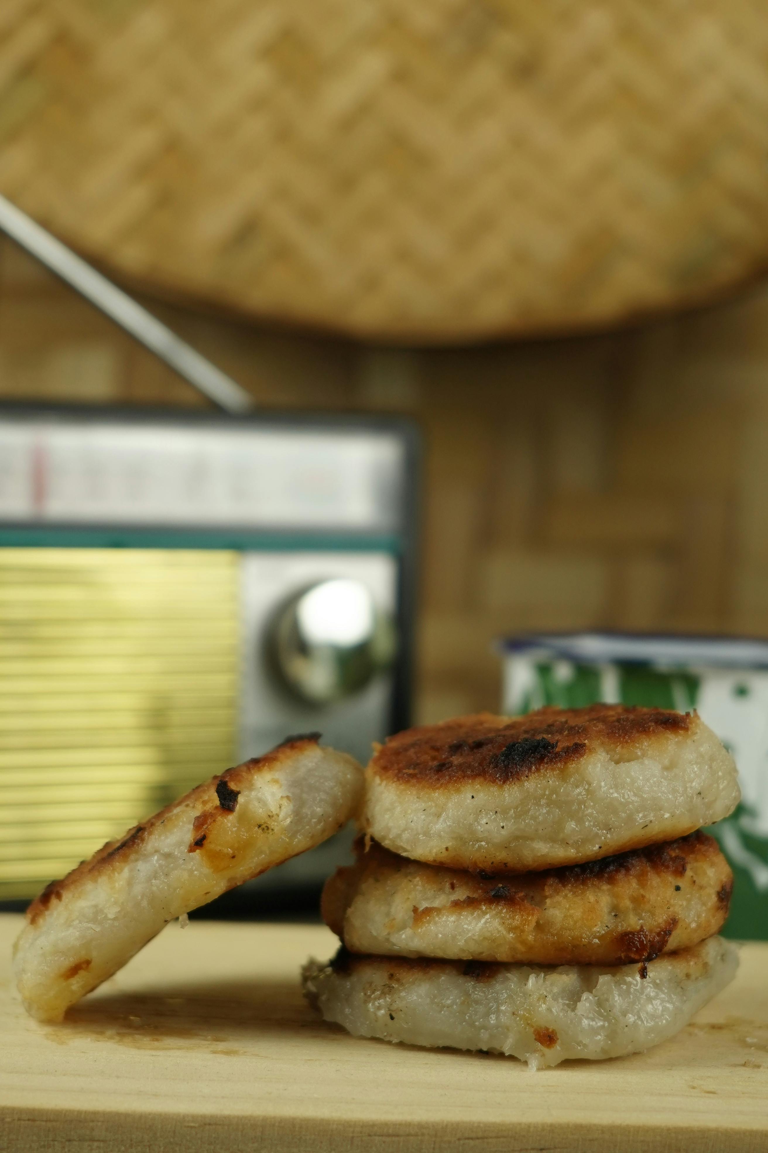 Homemade rice patties stacked on a wooden board with a vintage radio in the background.