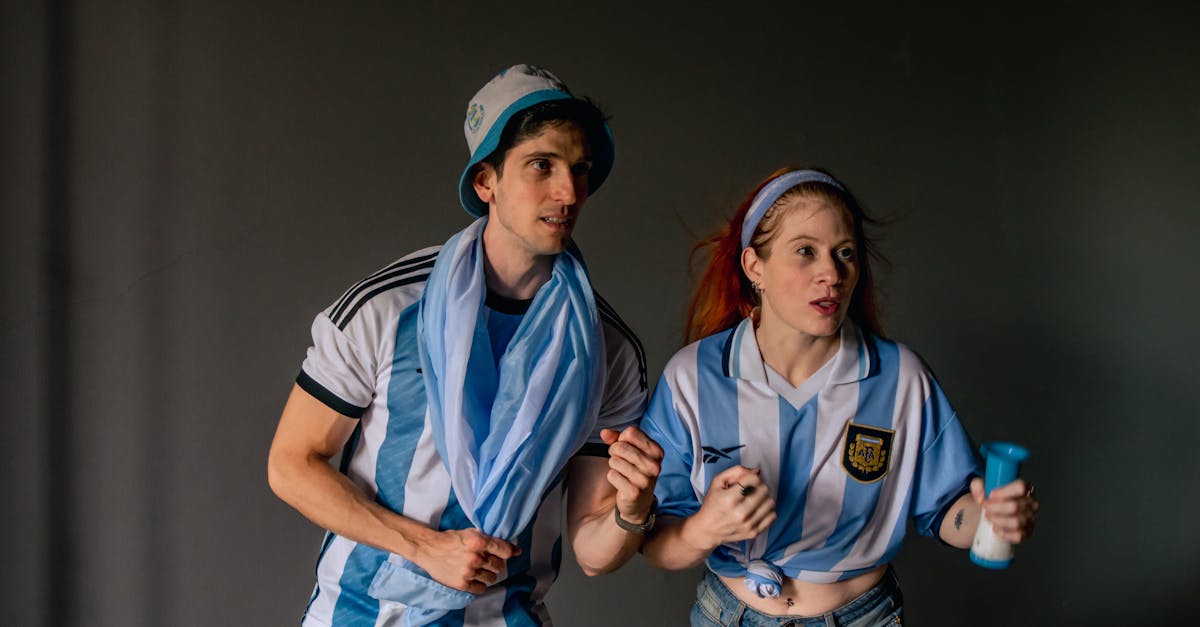Two enthusiastic Argentina soccer fans cheer during a match. Perfect for sports and celebration themes.