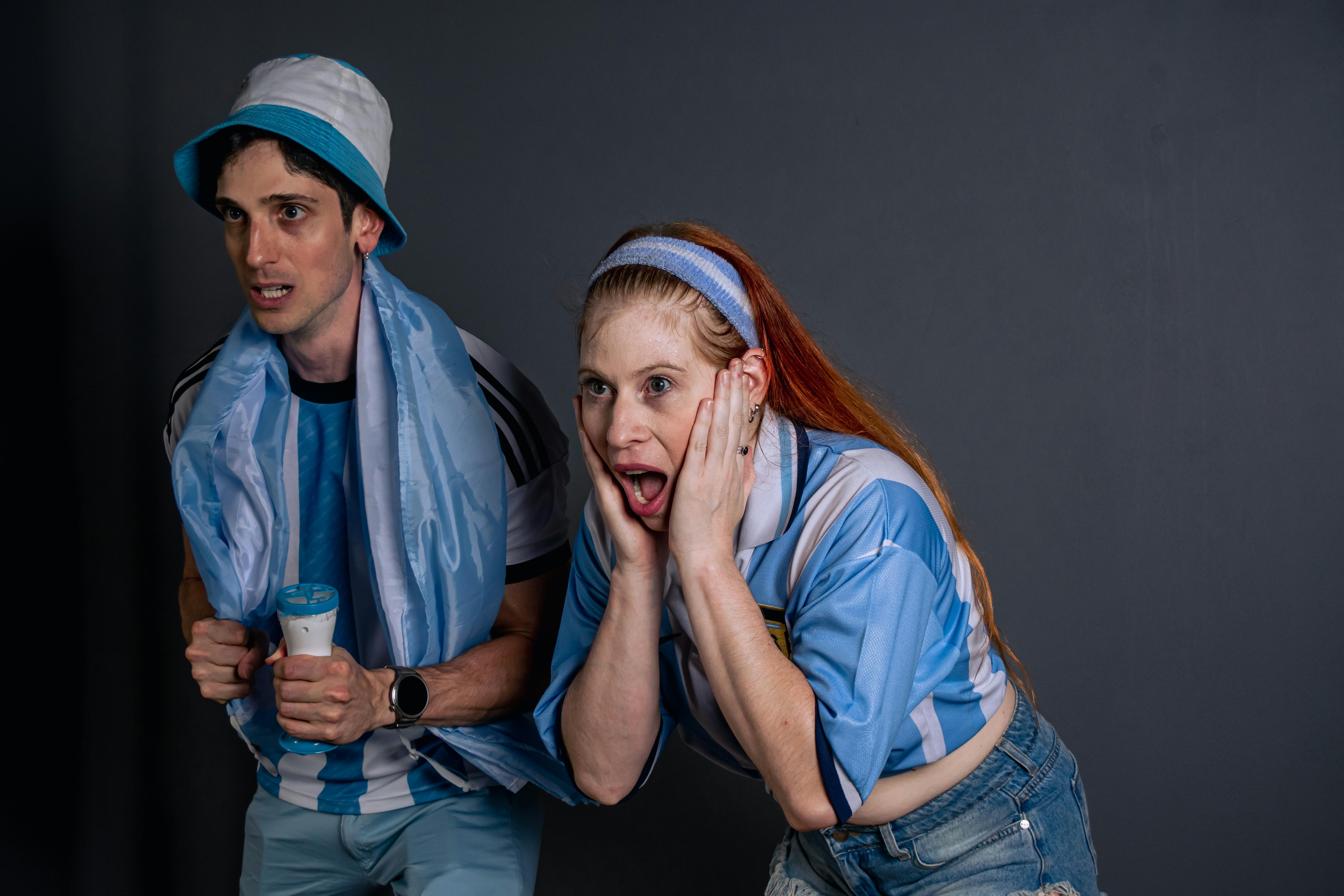 ฟรี แฟนกีฬาตัวยงสองคนส่งเสียงเชียร์อย่างสุดเสียงขณะชมการแข่งขันที่น่าตื่นเต้น คลังภาพถ่าย