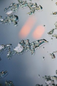 Intricate macro shot of melting ice with water droplets, revealing delicate textures.