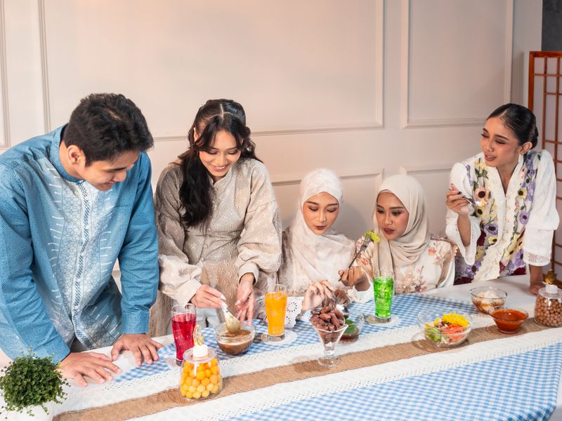 A group of adults enjoying a traditional meal indoors in Jakarta, Indonesia.