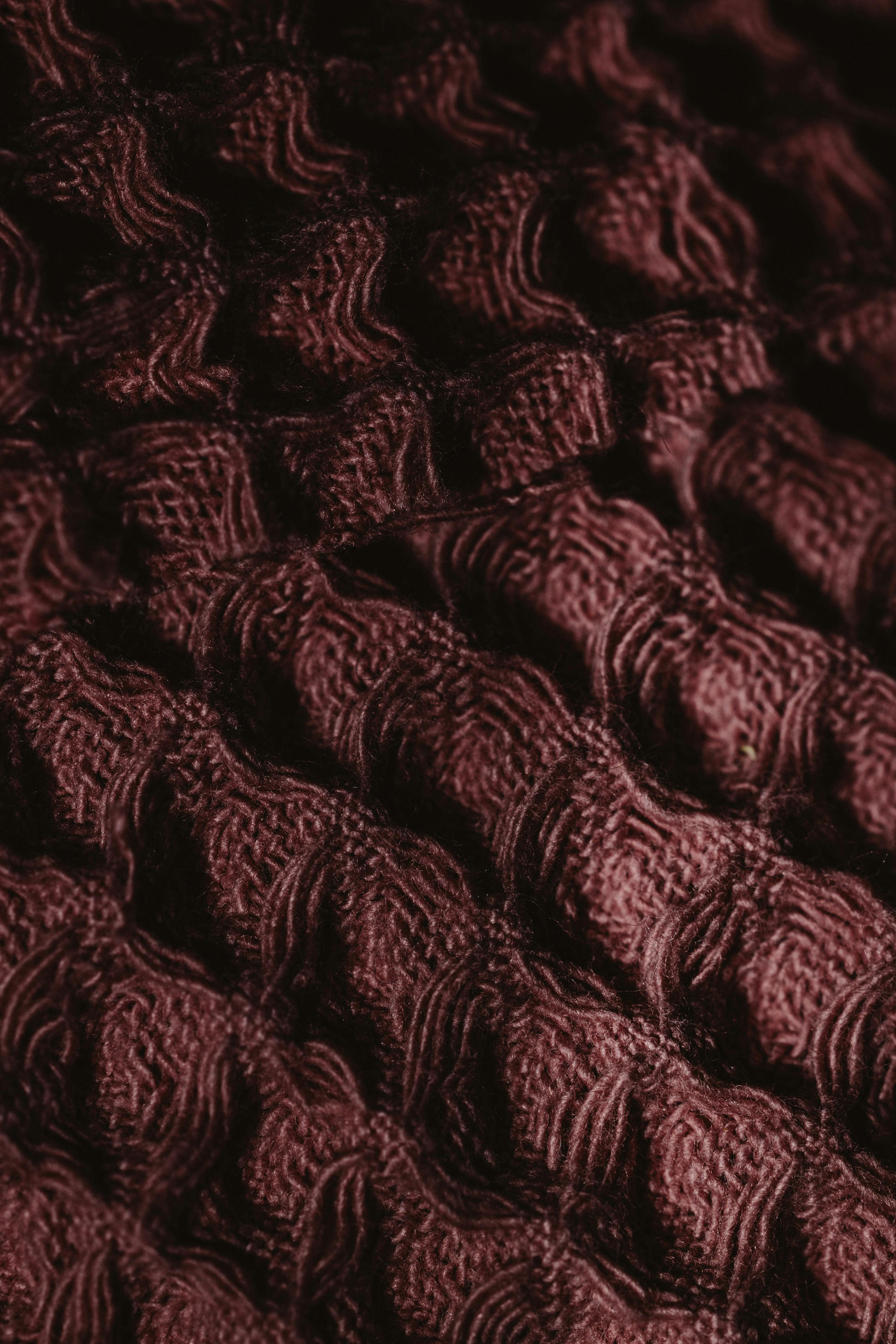 免费 酒红色纹理面料的特写，带有错综复杂的图案，非常适合用作背景或设计项目。 素材图片