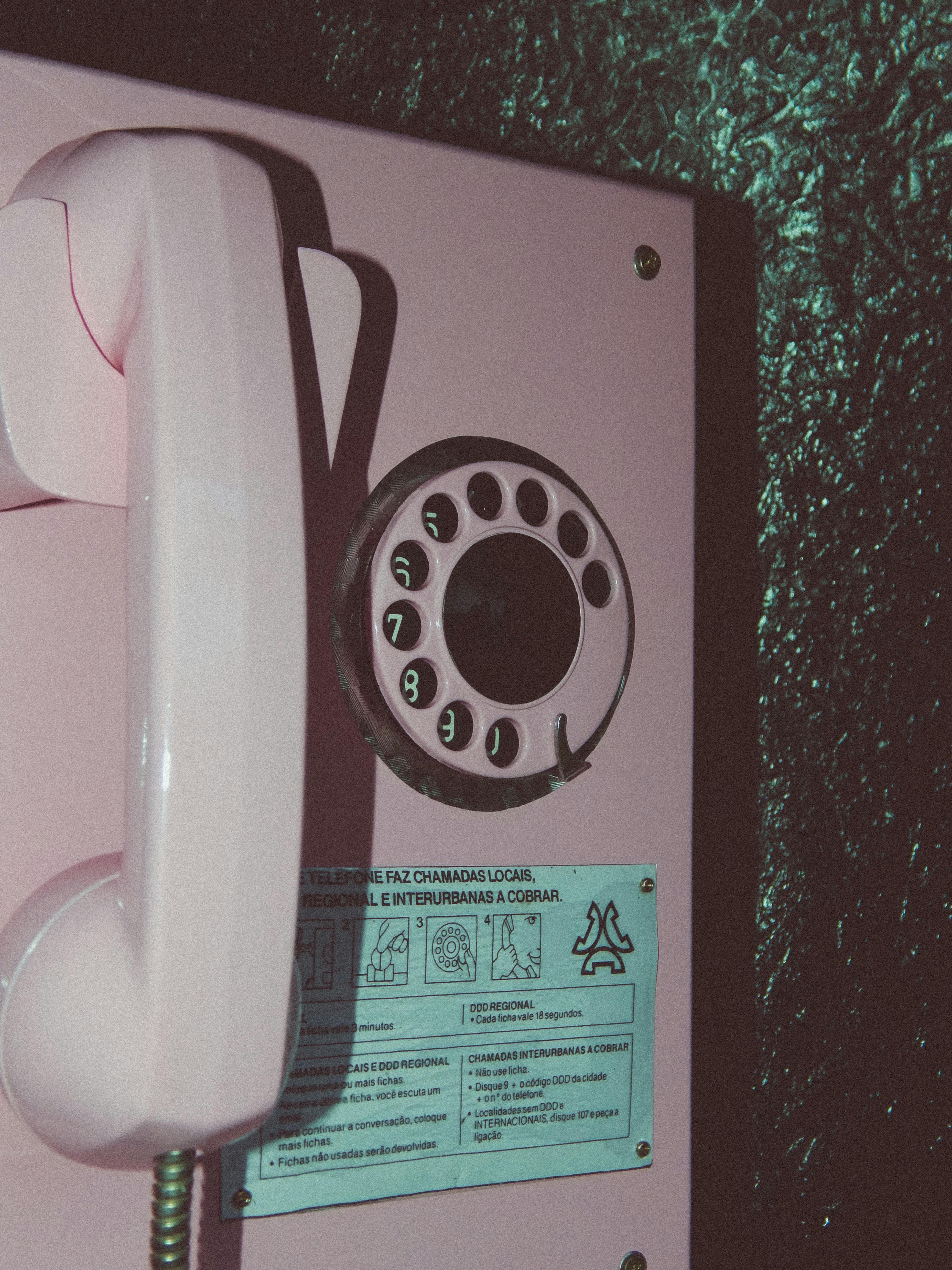 Free Close-up of a nostalgic pink rotary telephone on a textured wall. Stock Photo