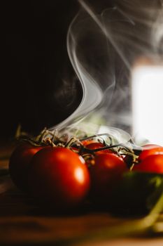 Artistic photo of fresh red tomatoes with a dramatic smoke effect.