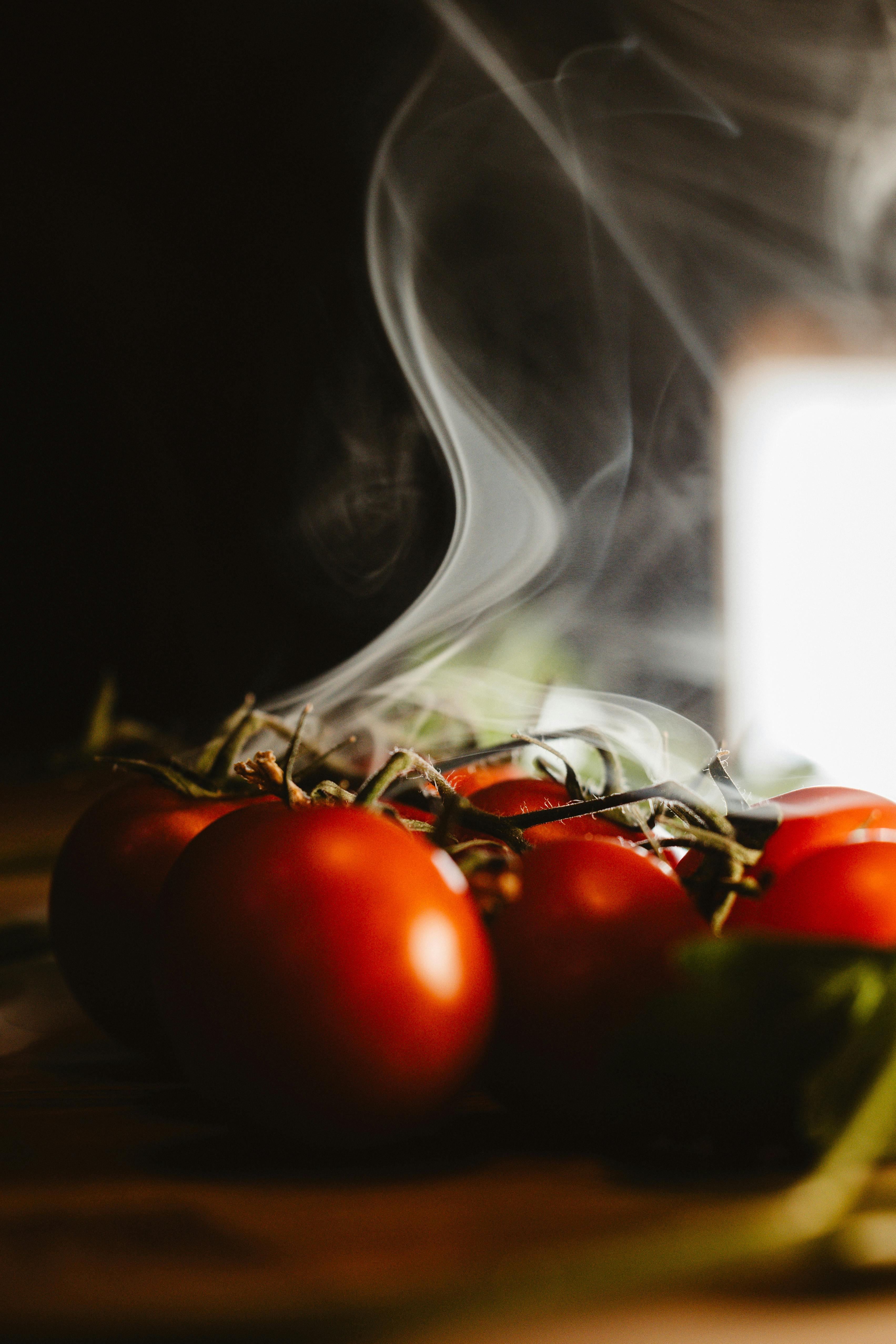 Zadarmo Umelecká fotografia čerstvých červených paradajok s dramatickým dymovým efektom. Fotka z fotobanky
