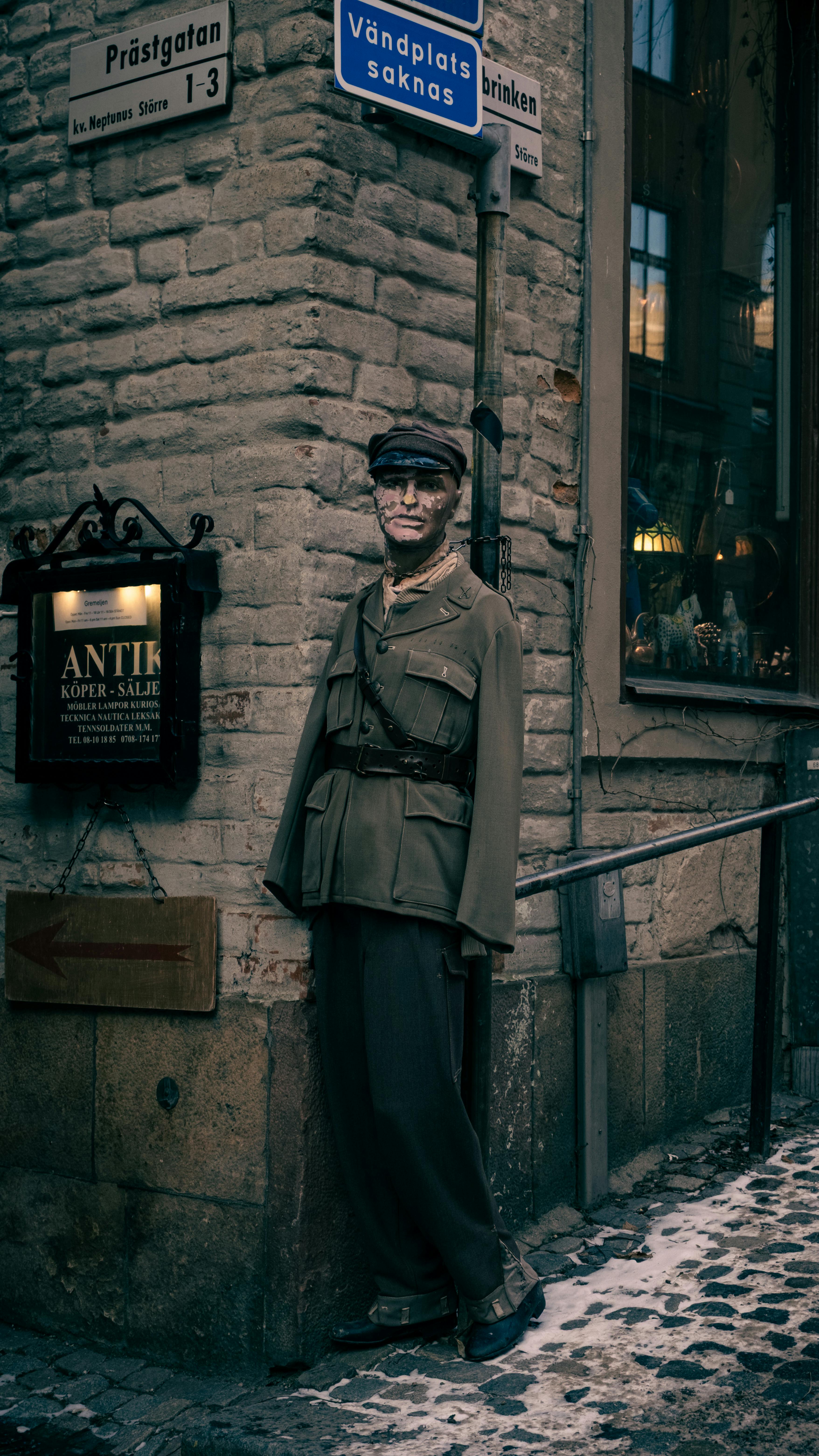 Ilmainen Sotilaaksi pukeutunut mannekiini seisoo kadunkulmassa Tukholman vanhassakaupungissa. Kuvapankkikuva